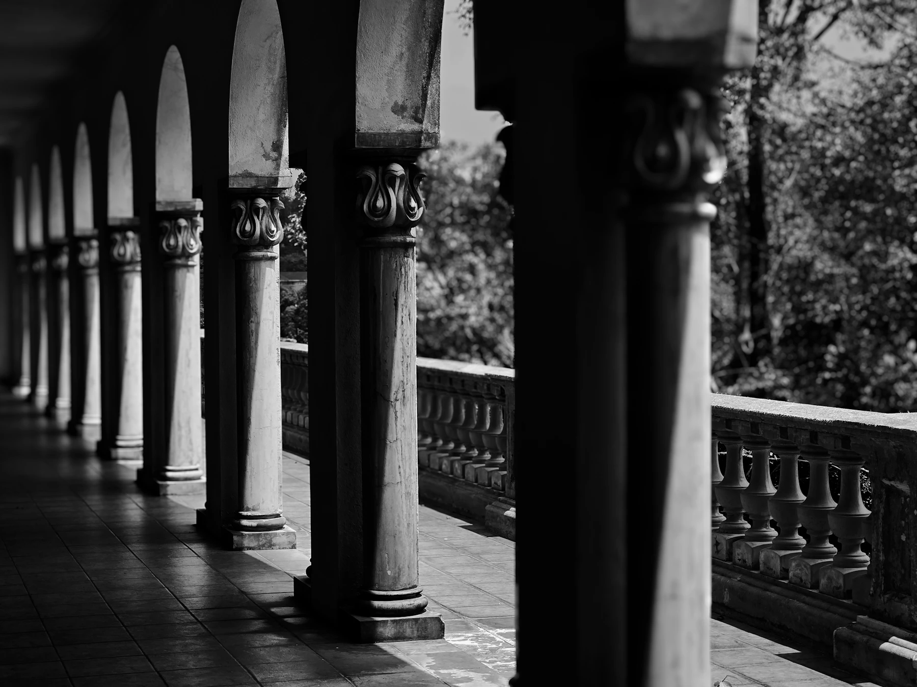 Rangée de colonnes classiques le long d'une galerie, noir et blanc