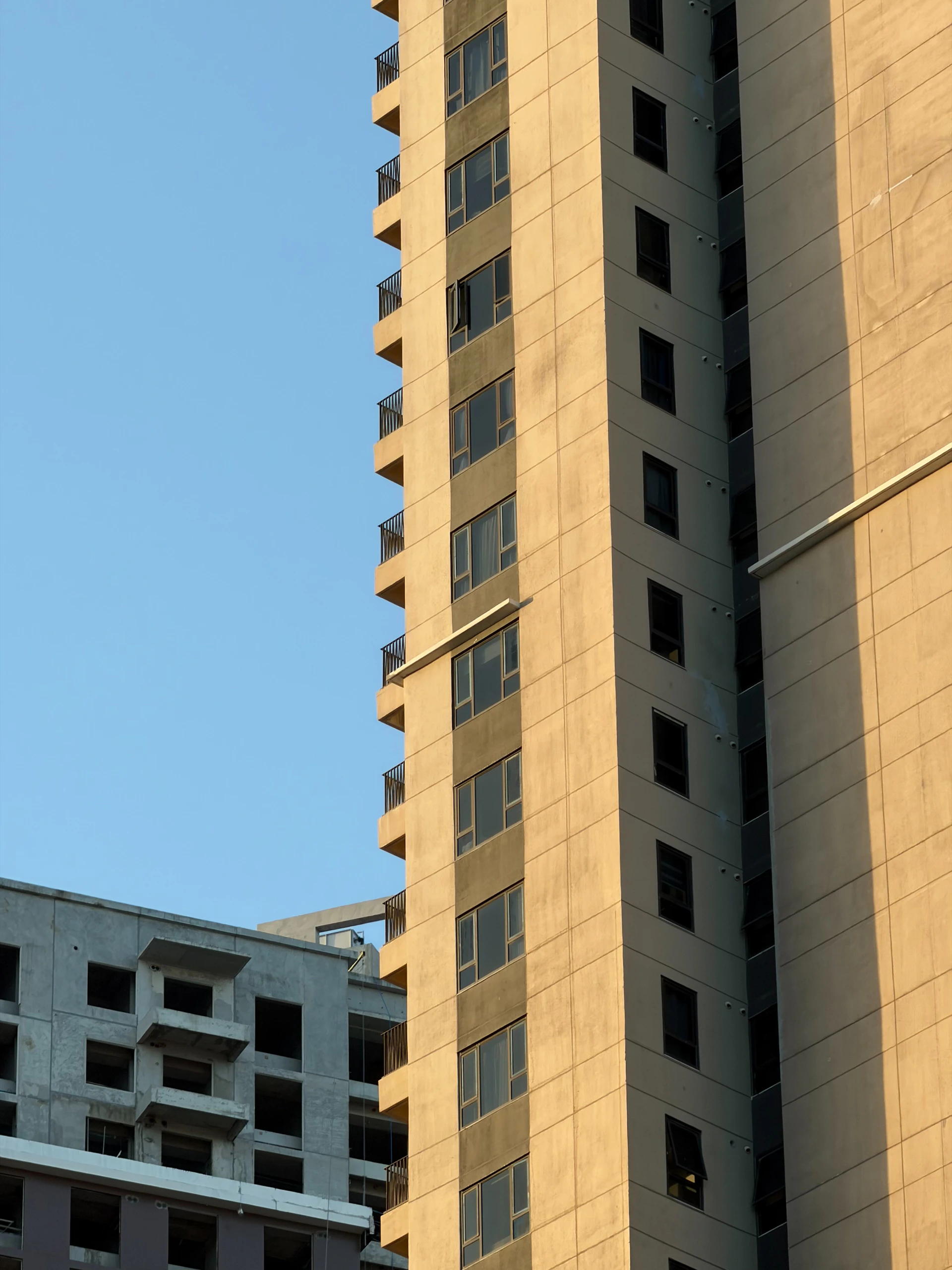 Tall concrete buildings against a clear blue sky