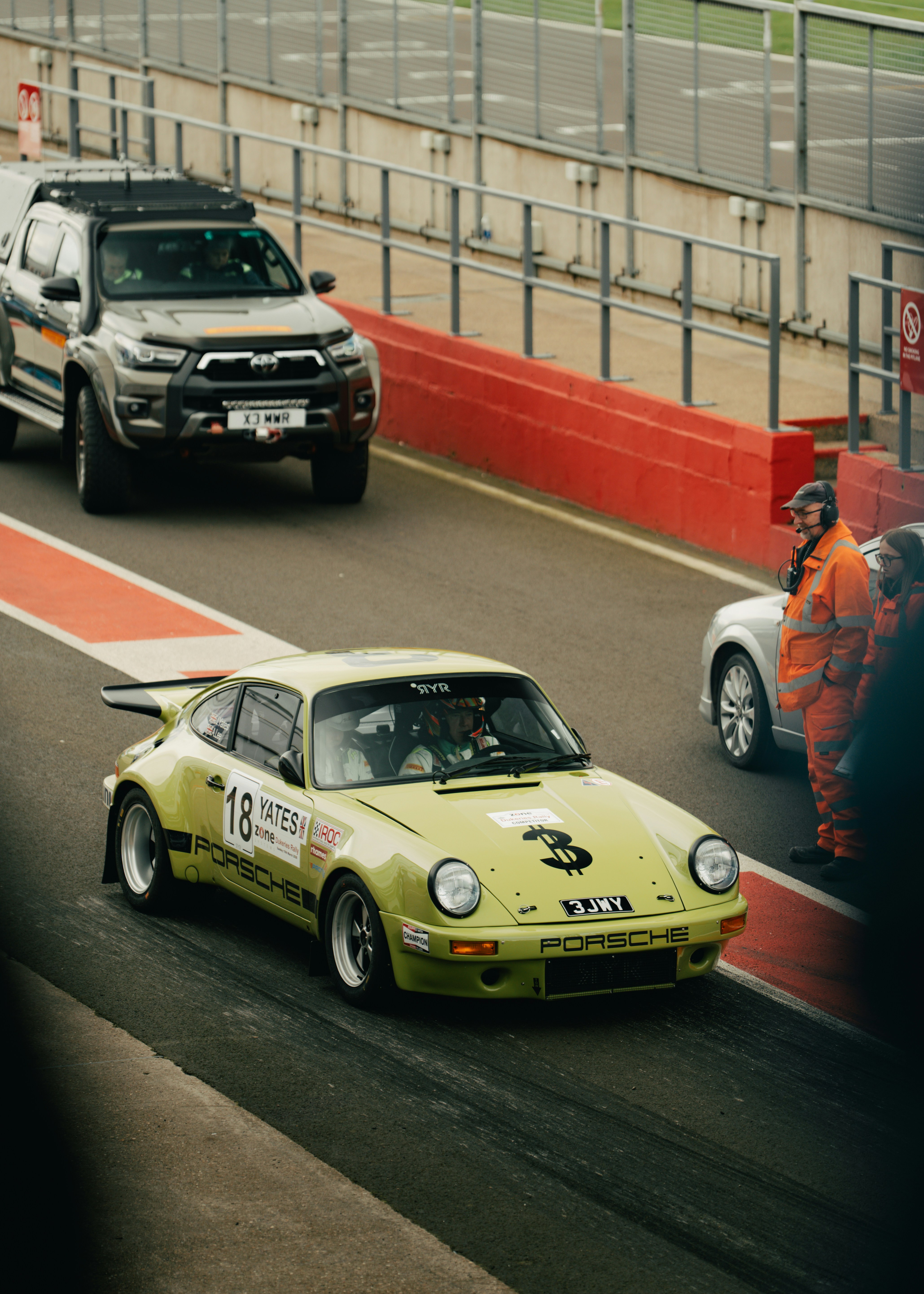 A yellow race car with number 3 on the hood.