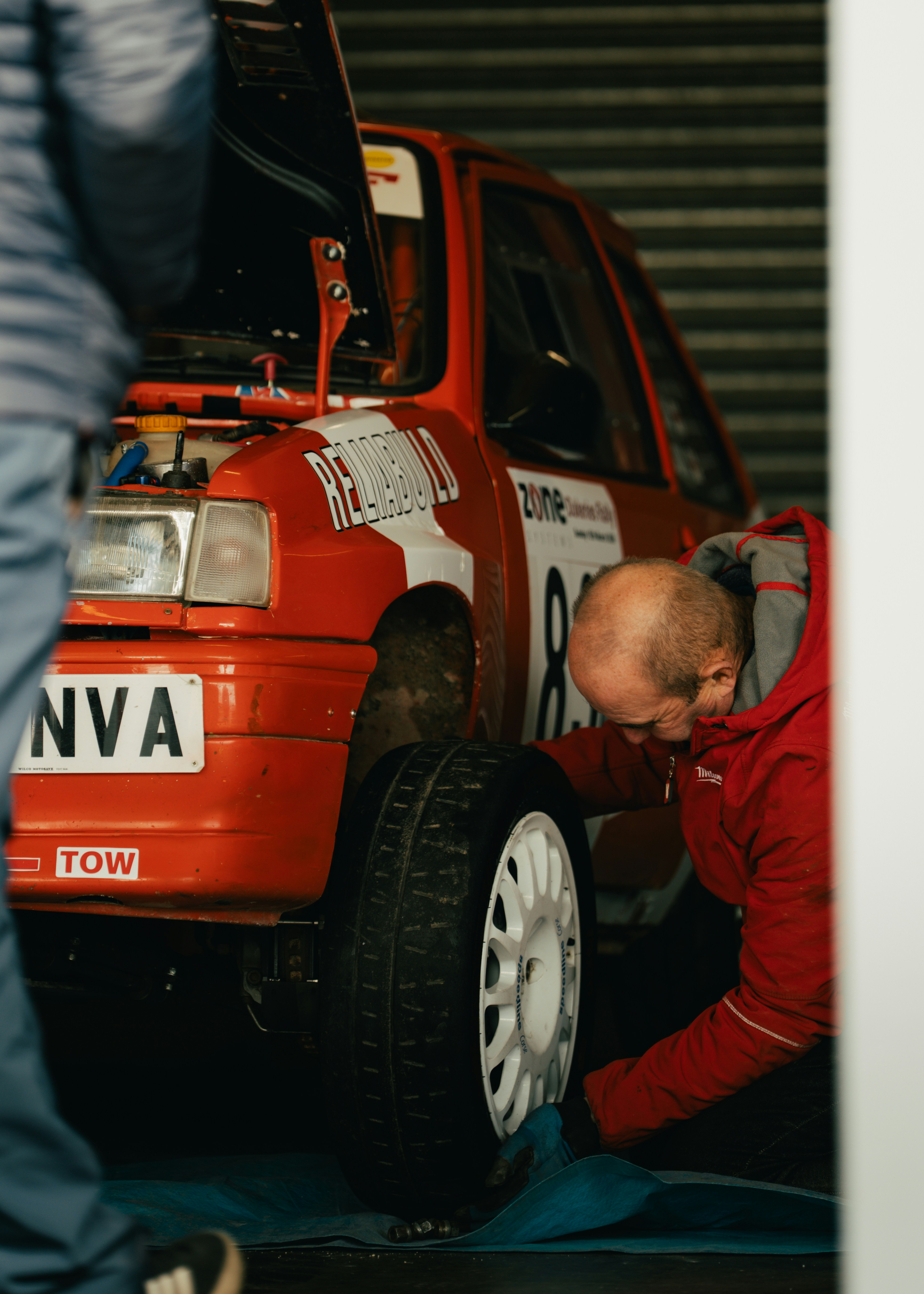 Mechanic working on a red rally car
