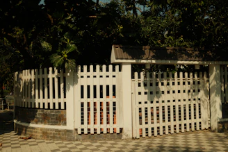 White picket fence surrounding a circular garden area.