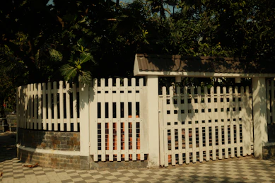 White picket fence surrounding a circular garden area.