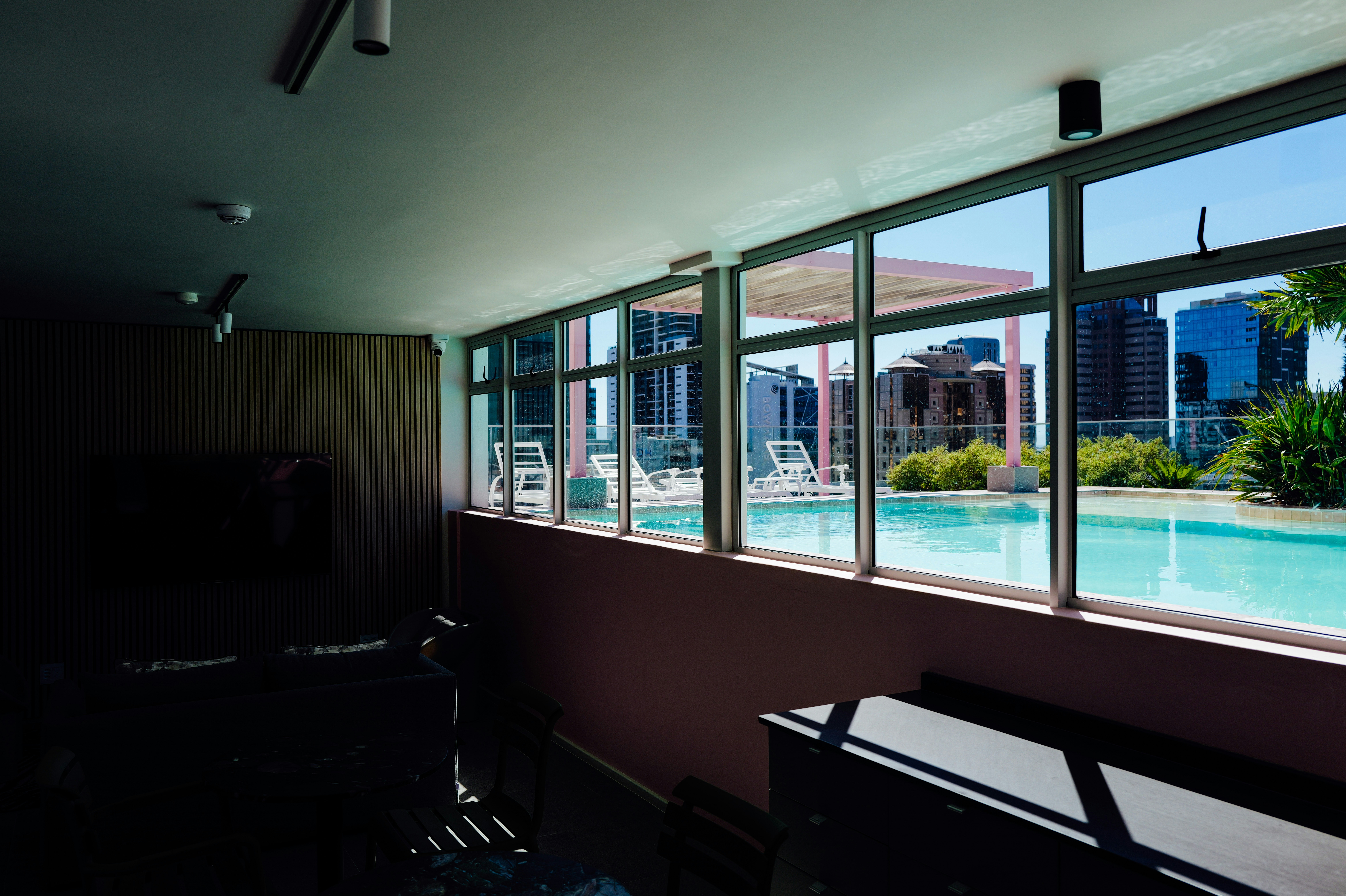 Indoor pool area with large windows overlooking city