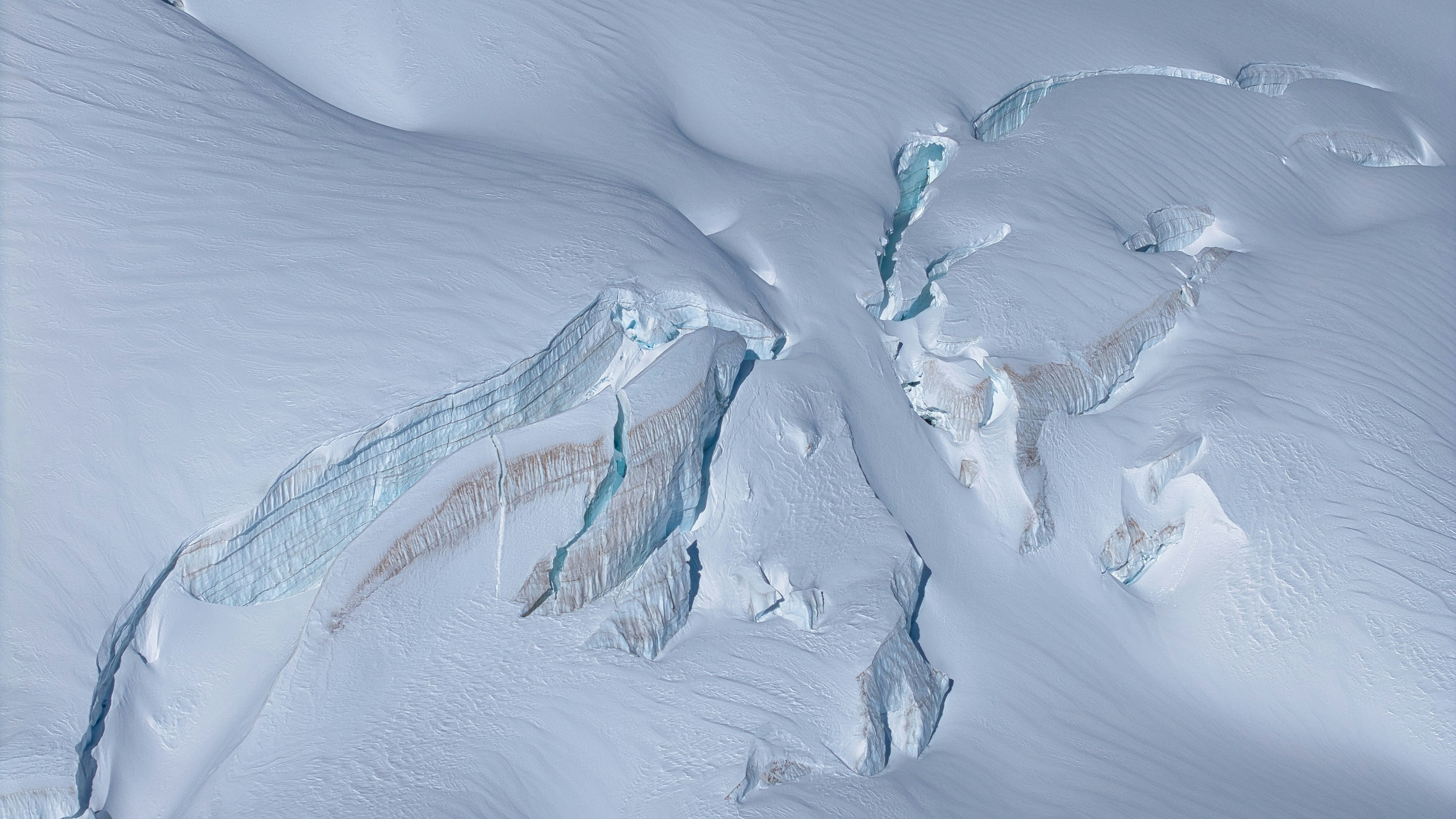 Cracked ice surface with blue and brown streaks