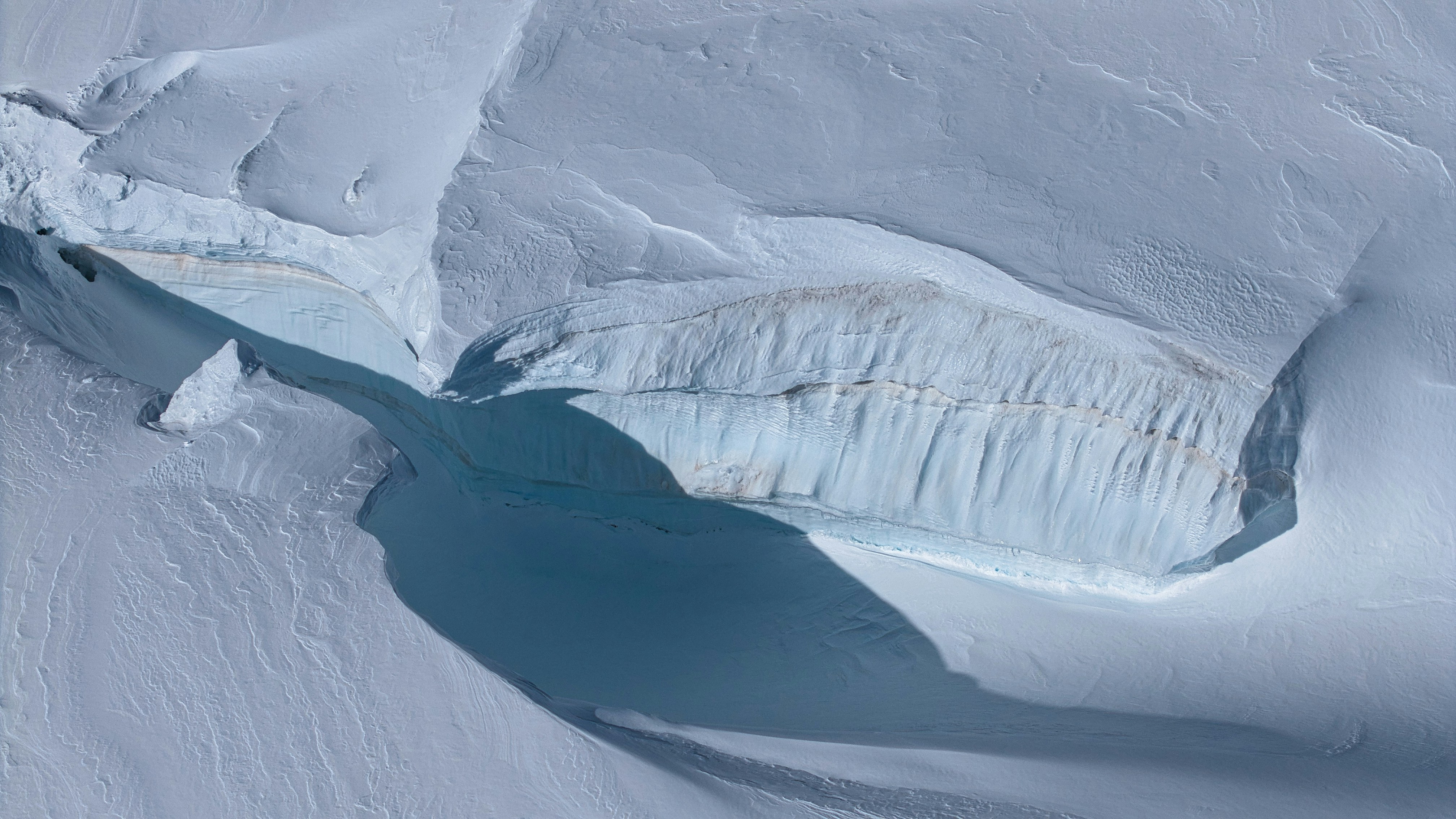 Aerial view of a glacial crevasse with layered ice