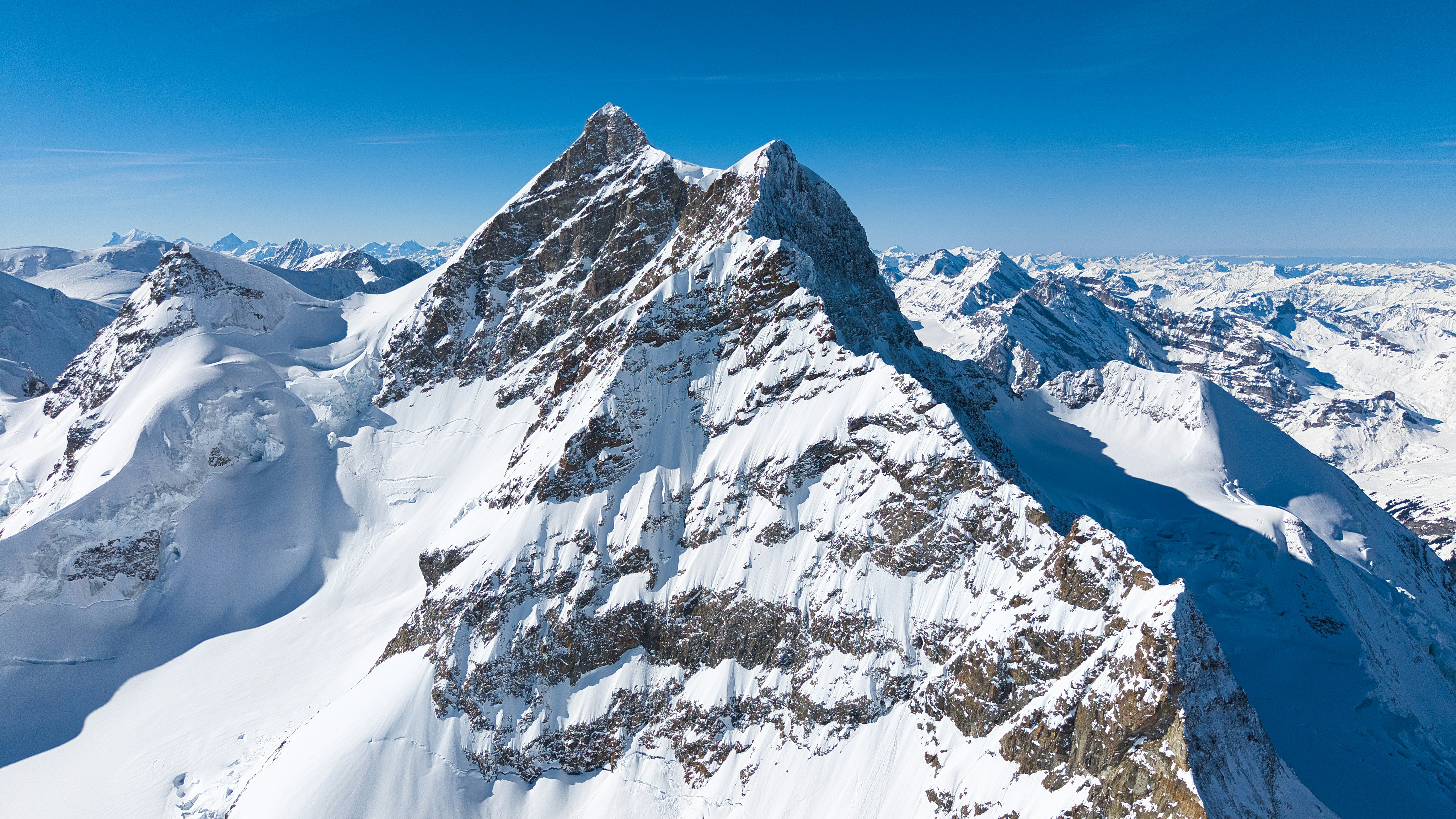 Snow-covered mountains under a clear blue sky