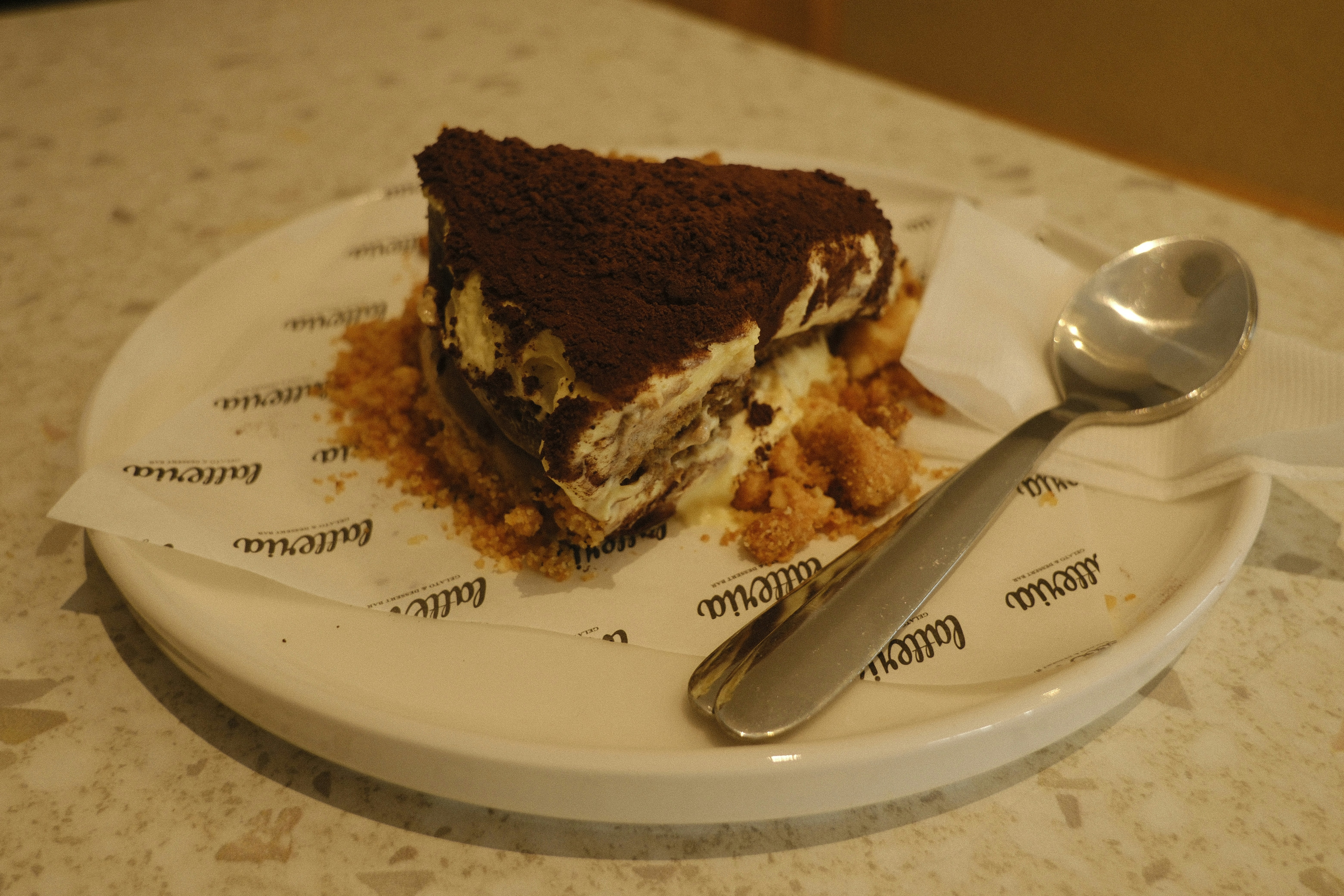 A slice of tiramisu cake with a spoon.