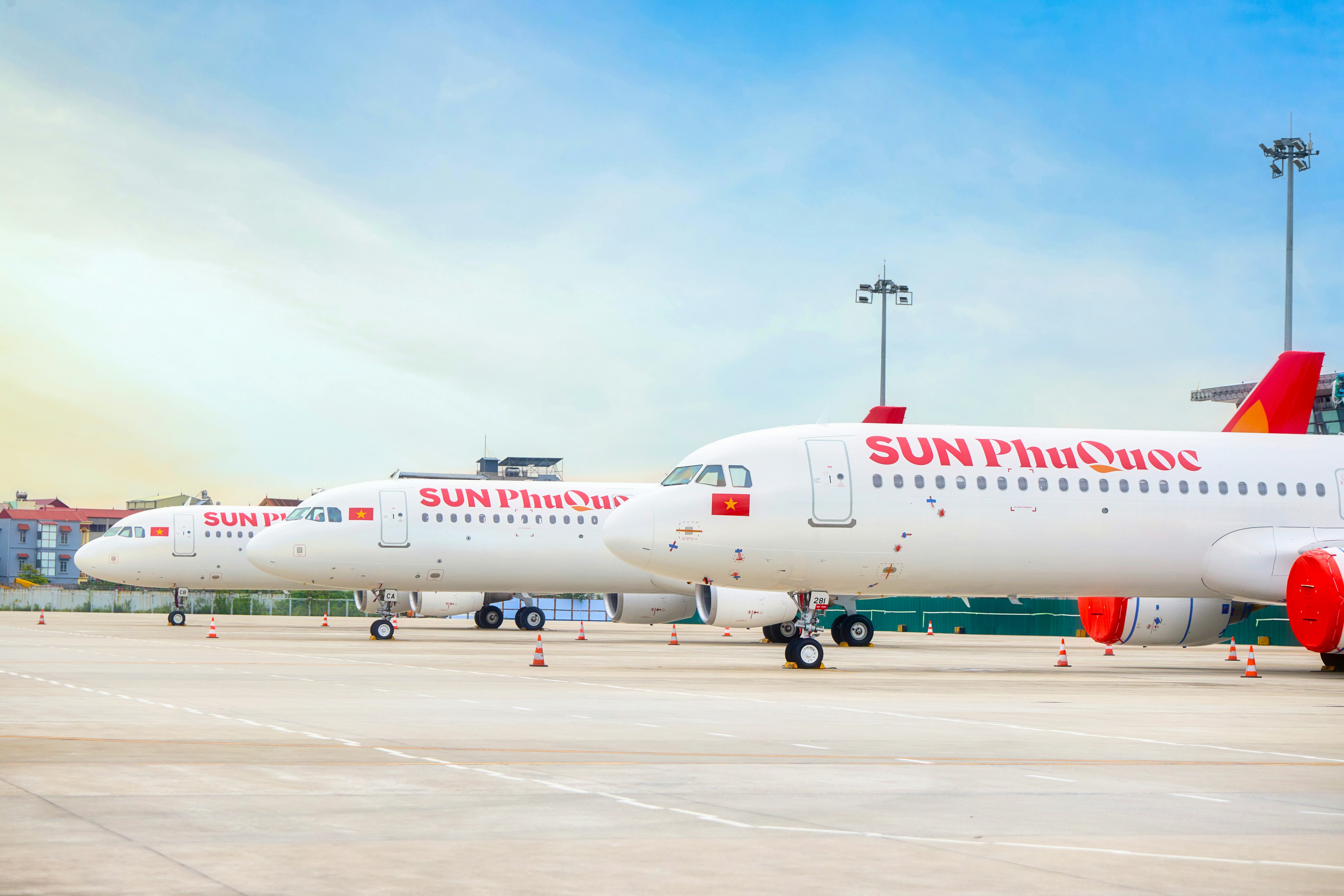明るい空の下、滑走路に3機の飛行機が停機していた。