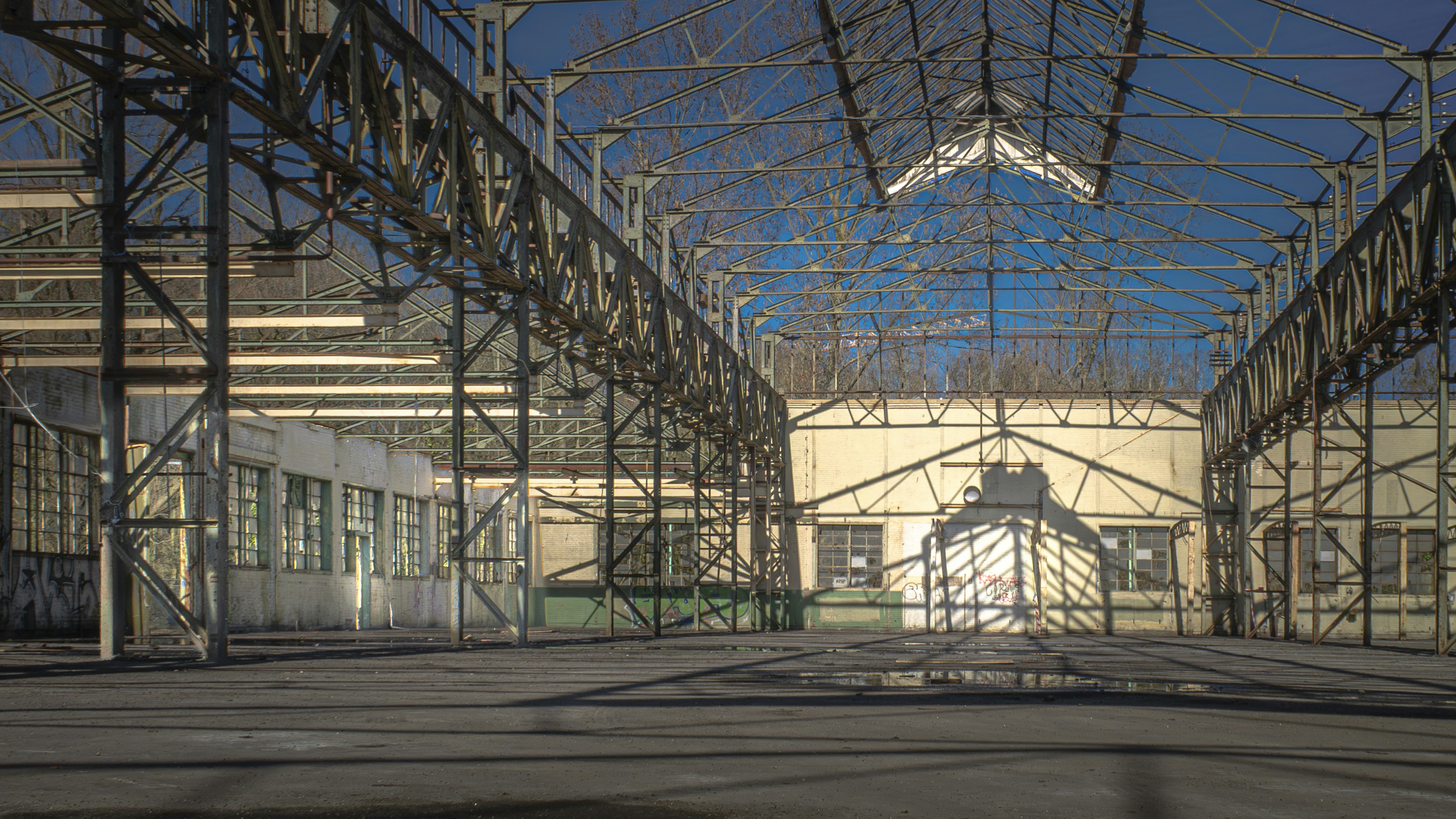 Interior of an abandoned industrial warehouse with exposed beams.