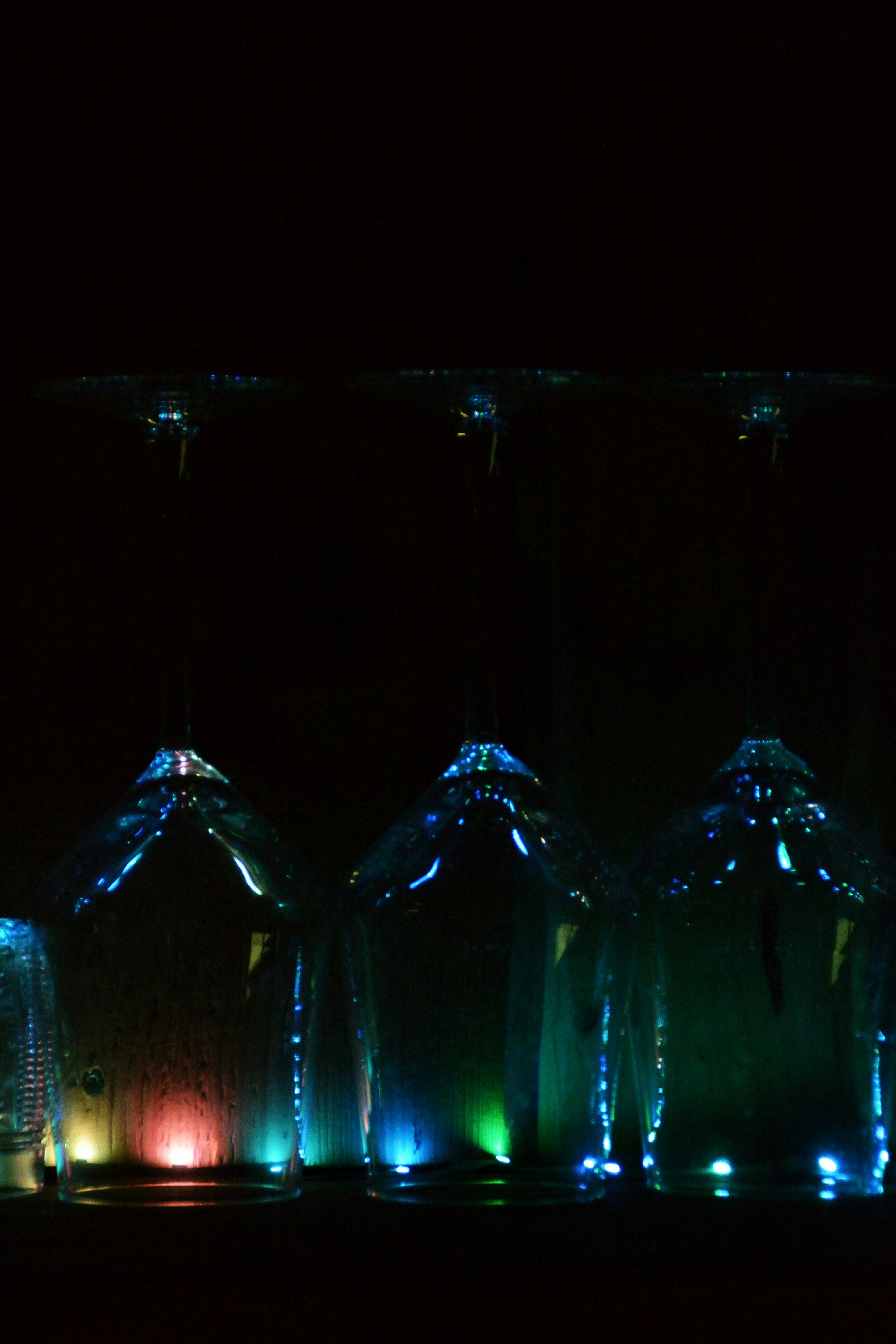 Trois bouteilles en verre illuminées de lumières colorées