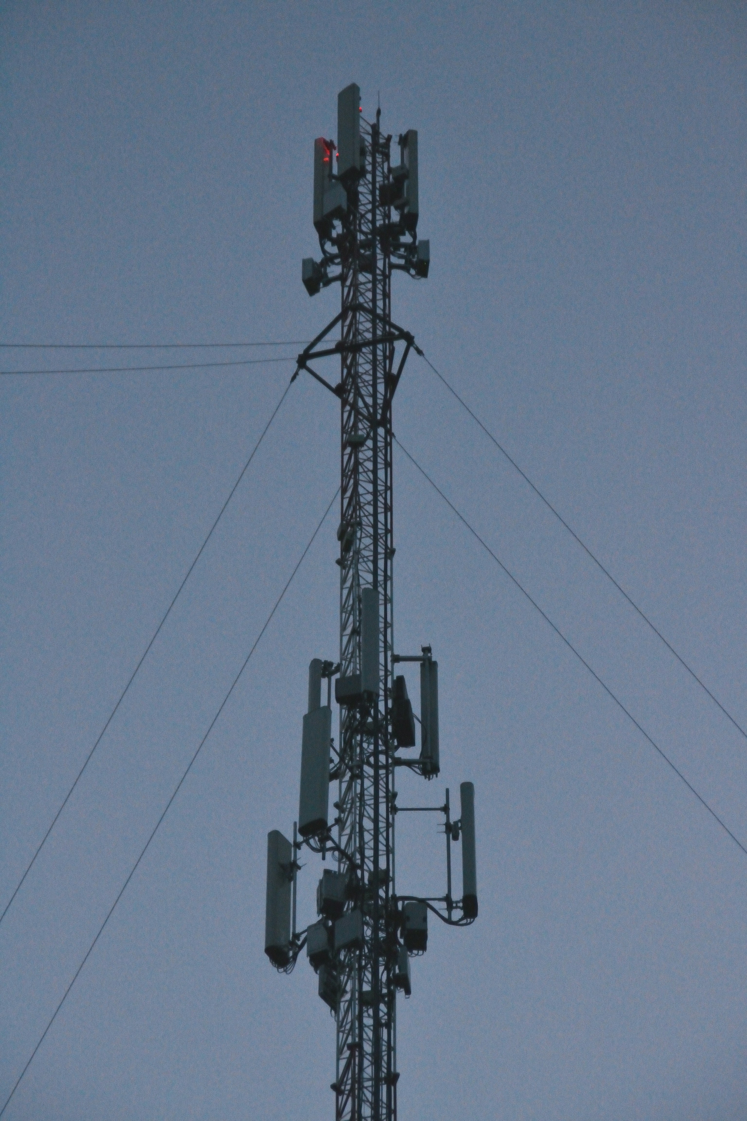 A tall cell tower with antennas against the sky