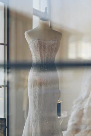 A strapless white gown on a mannequin in a window