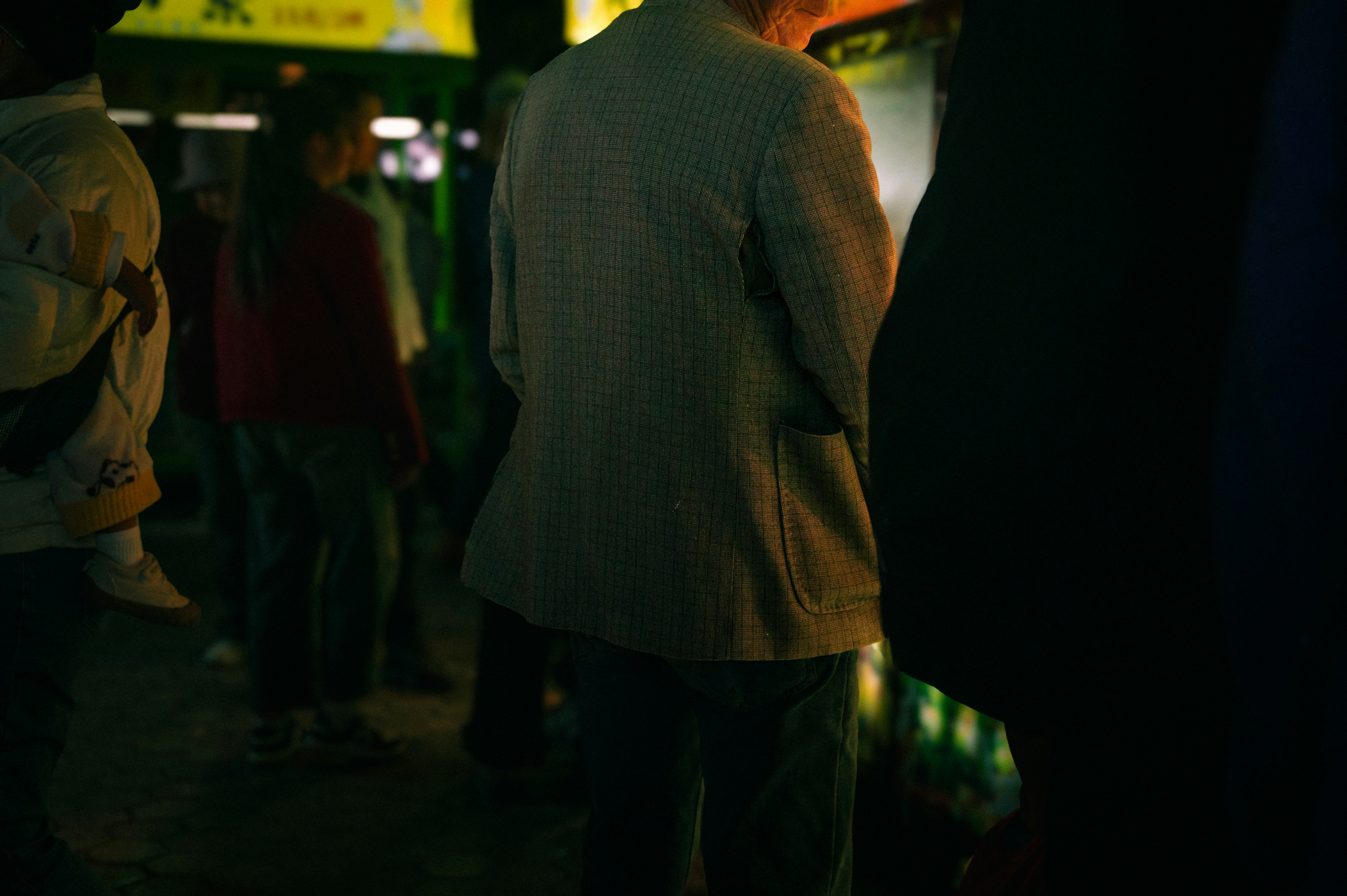 People standing in a dimly lit outdoor area.