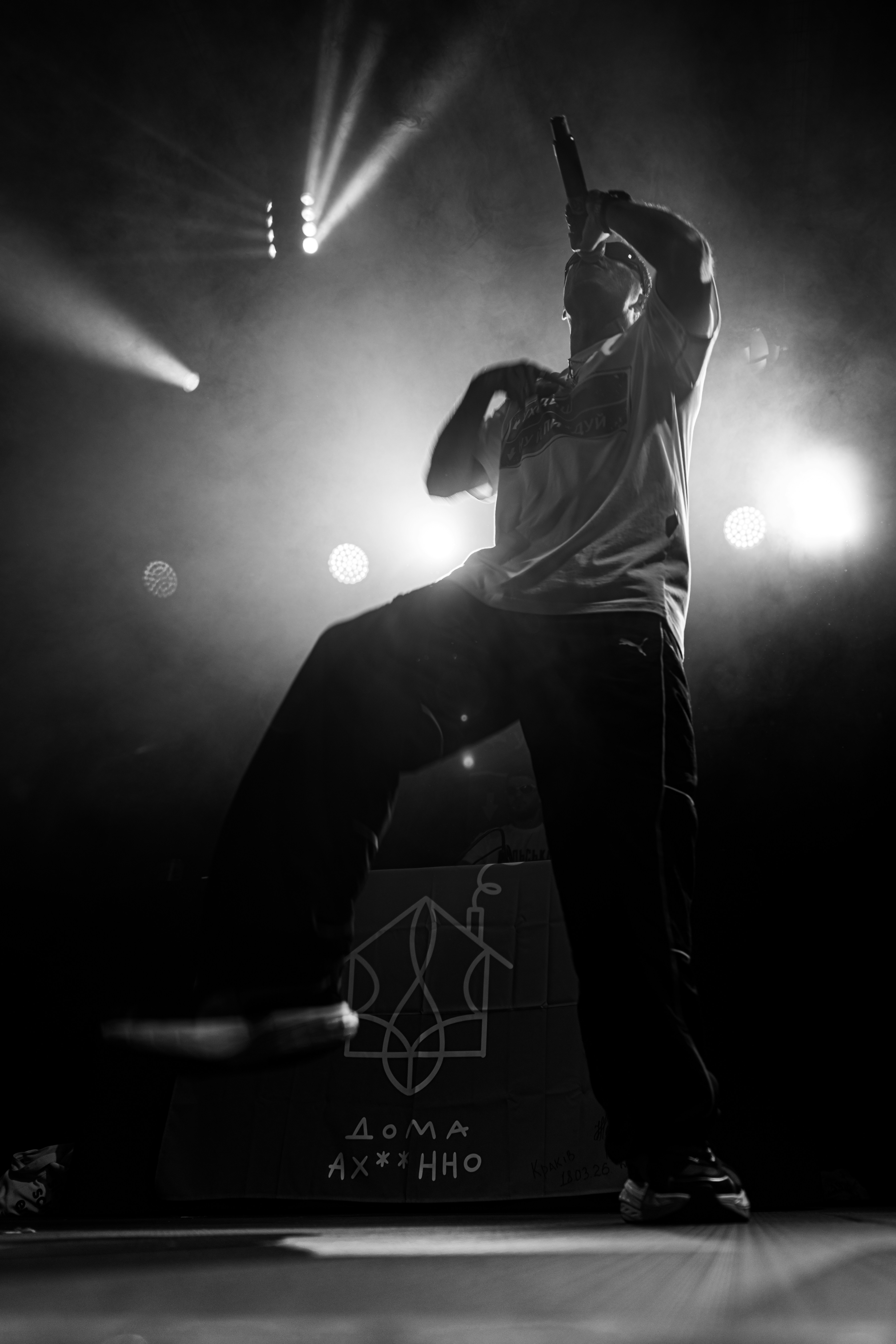 A rapper performs on stage with bright lights