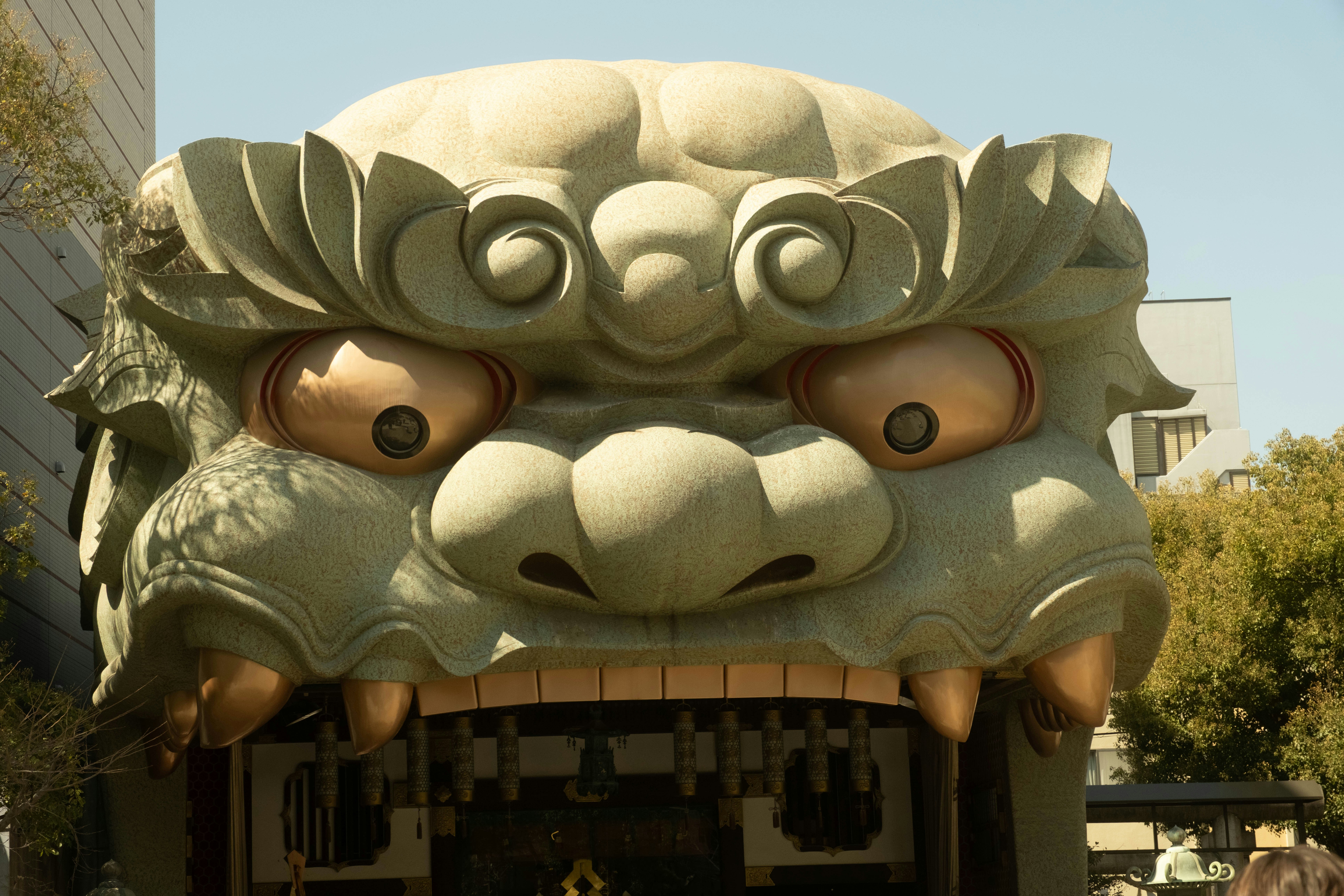 A large, ornate stone lion head sculpture outdoors.