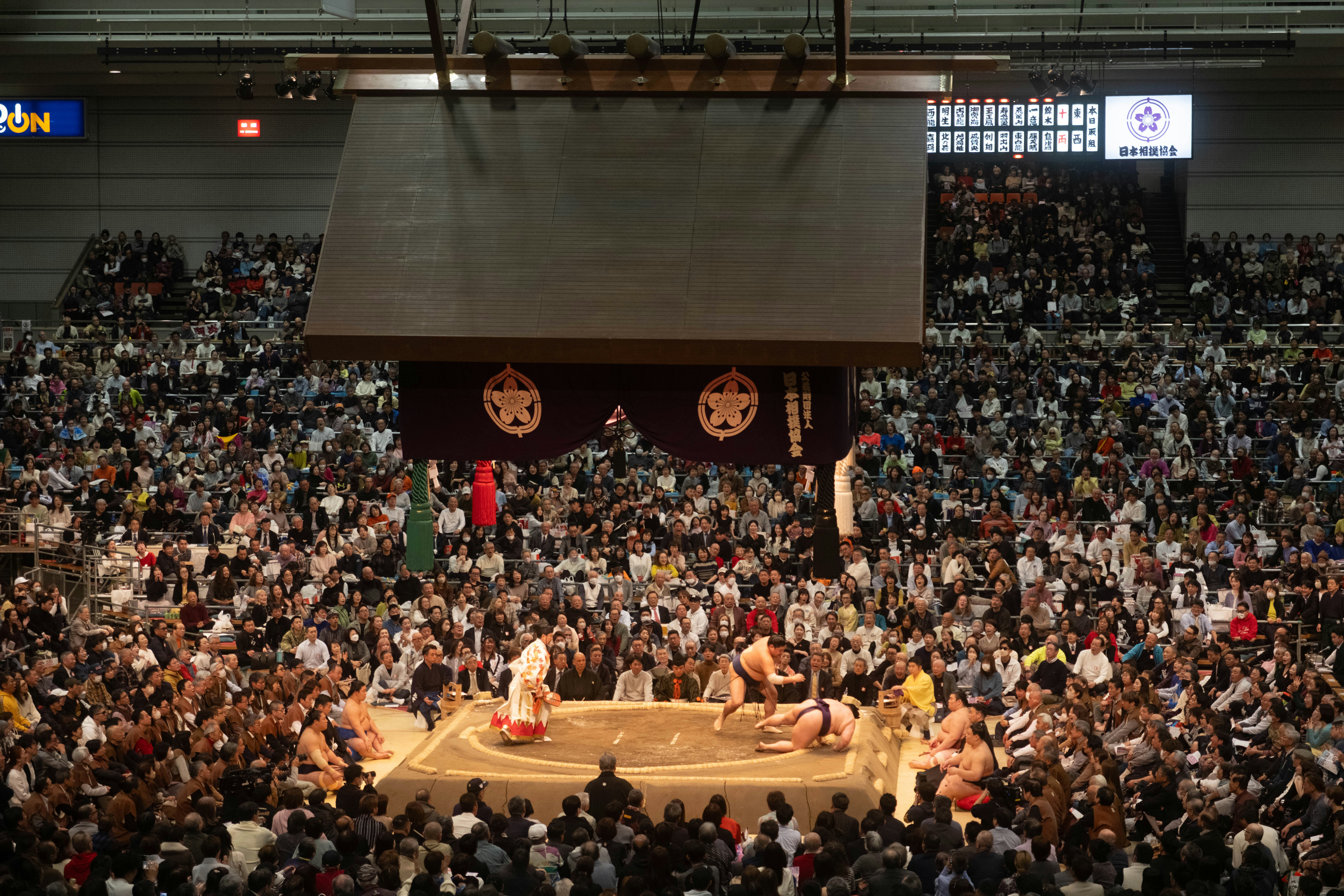 Pegulat sumo bersaing di arena yang penuh sesak.
