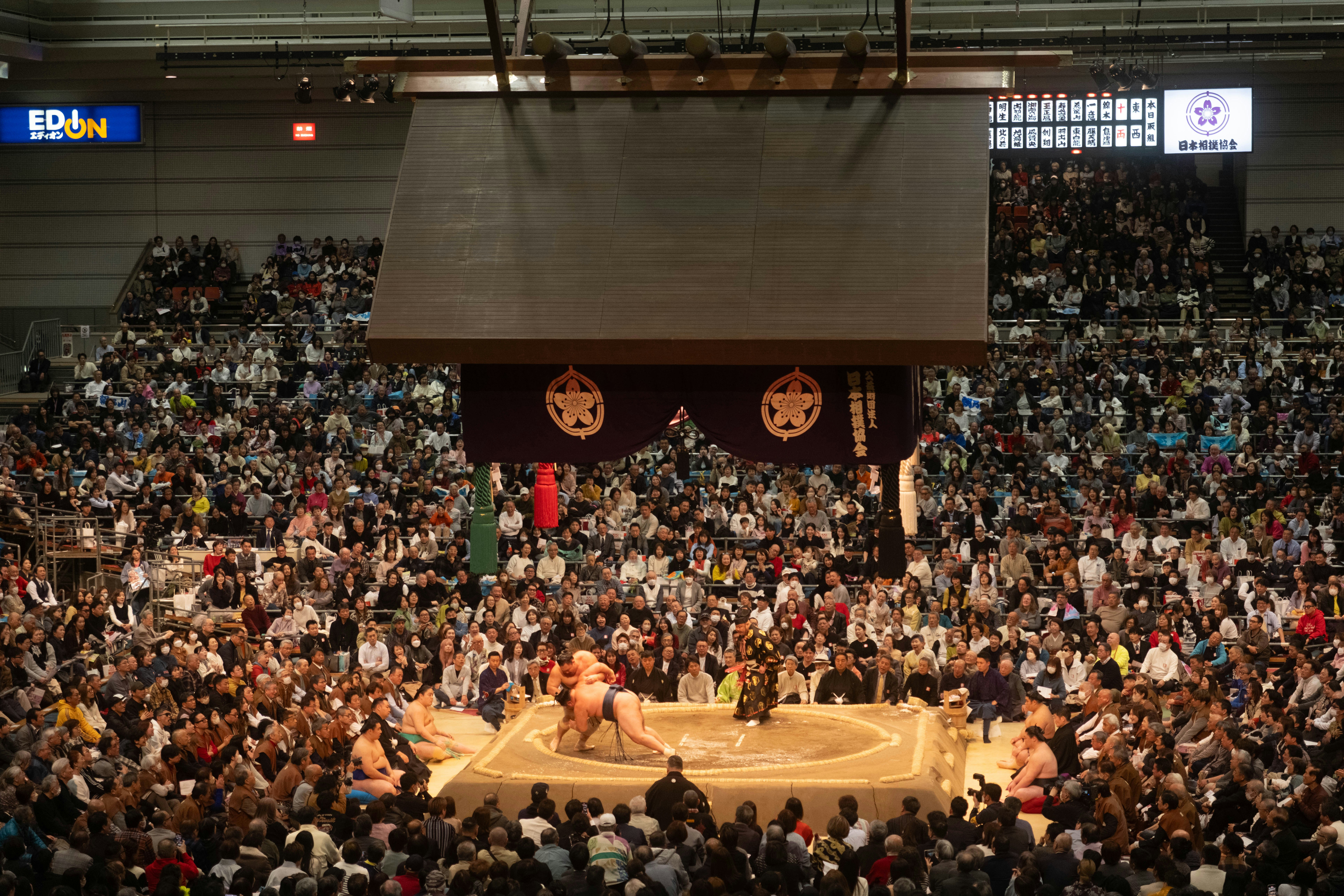 Pegulat sumo bersaing di arena stadion yang penuh sesak.