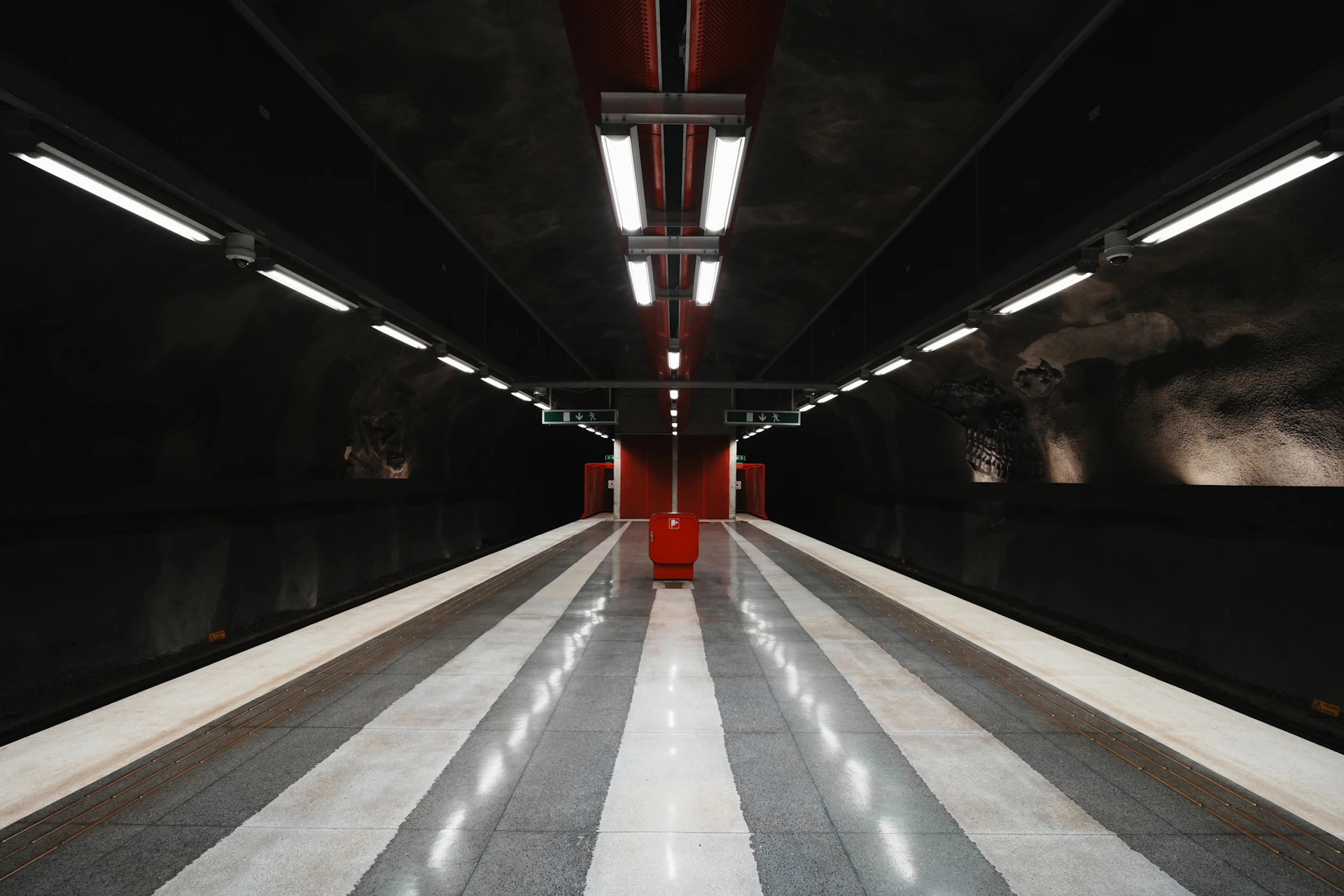 Modern subway station with striped platform and red accents