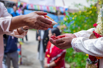 Hands exchanging offerings during a cultural ceremony.