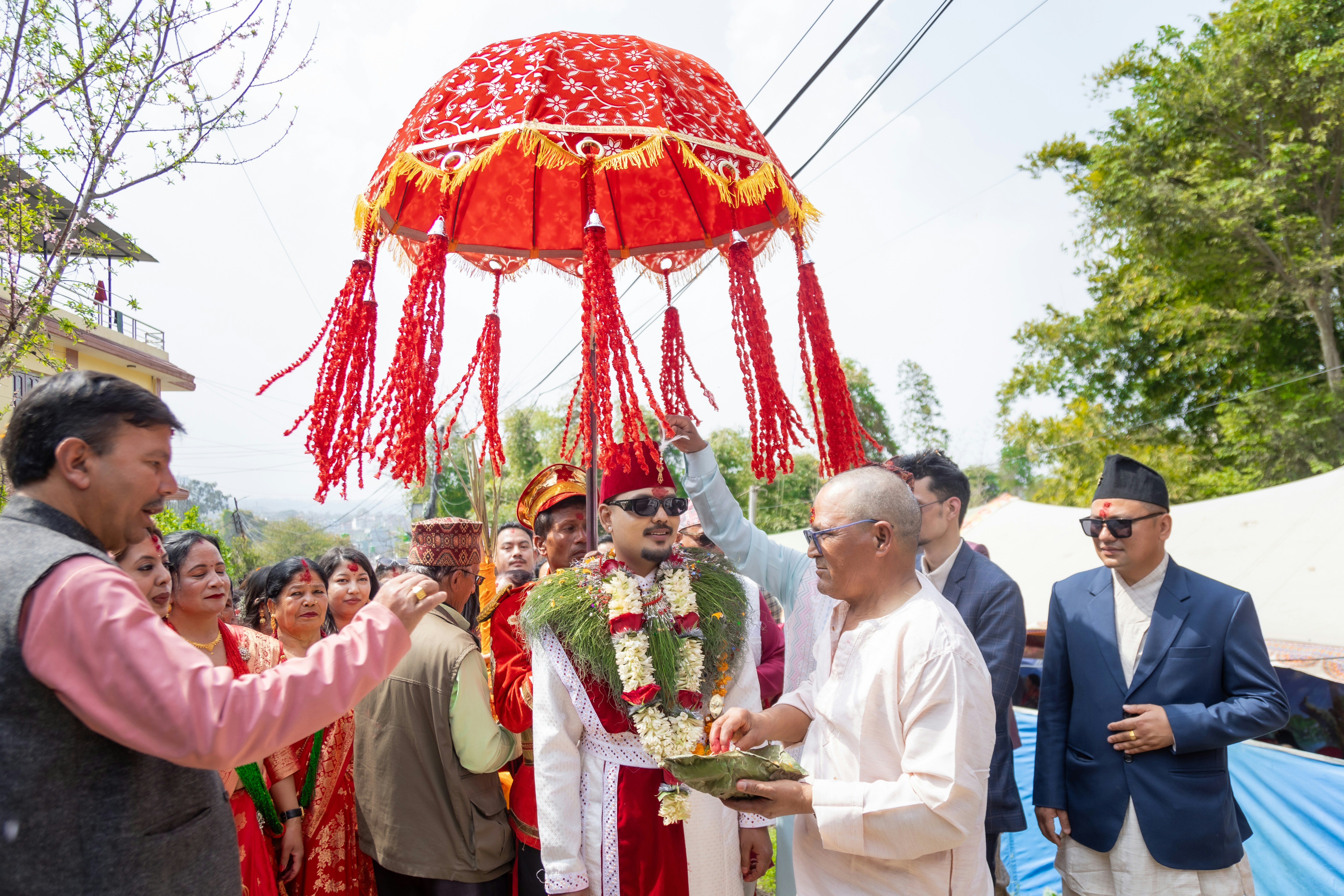 Épouser en tenue traditionnelle sous un parapluie décoratif