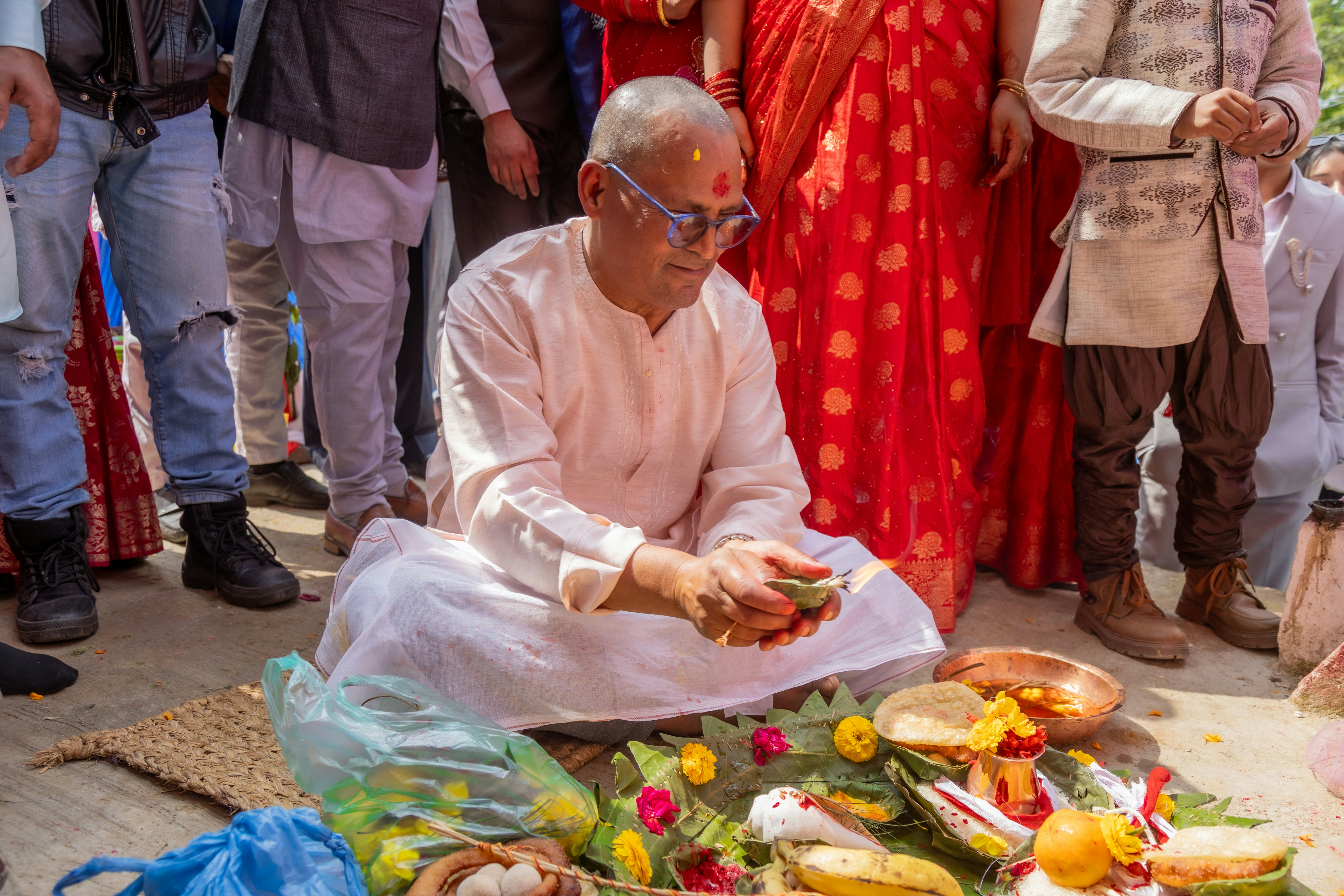 Elderly man performs religious ritual with offerings