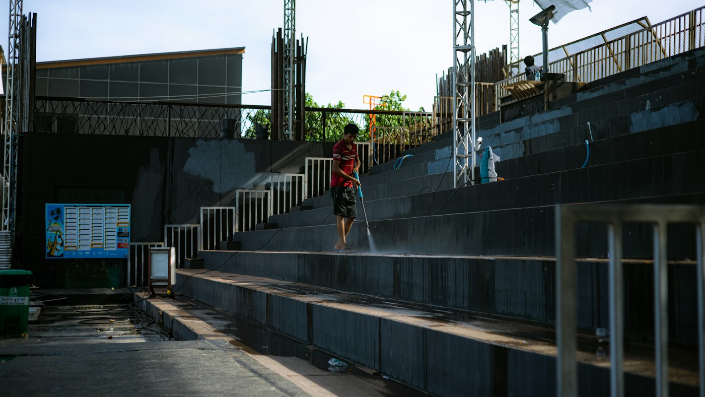 Person pressure washing concrete steps in Sydney