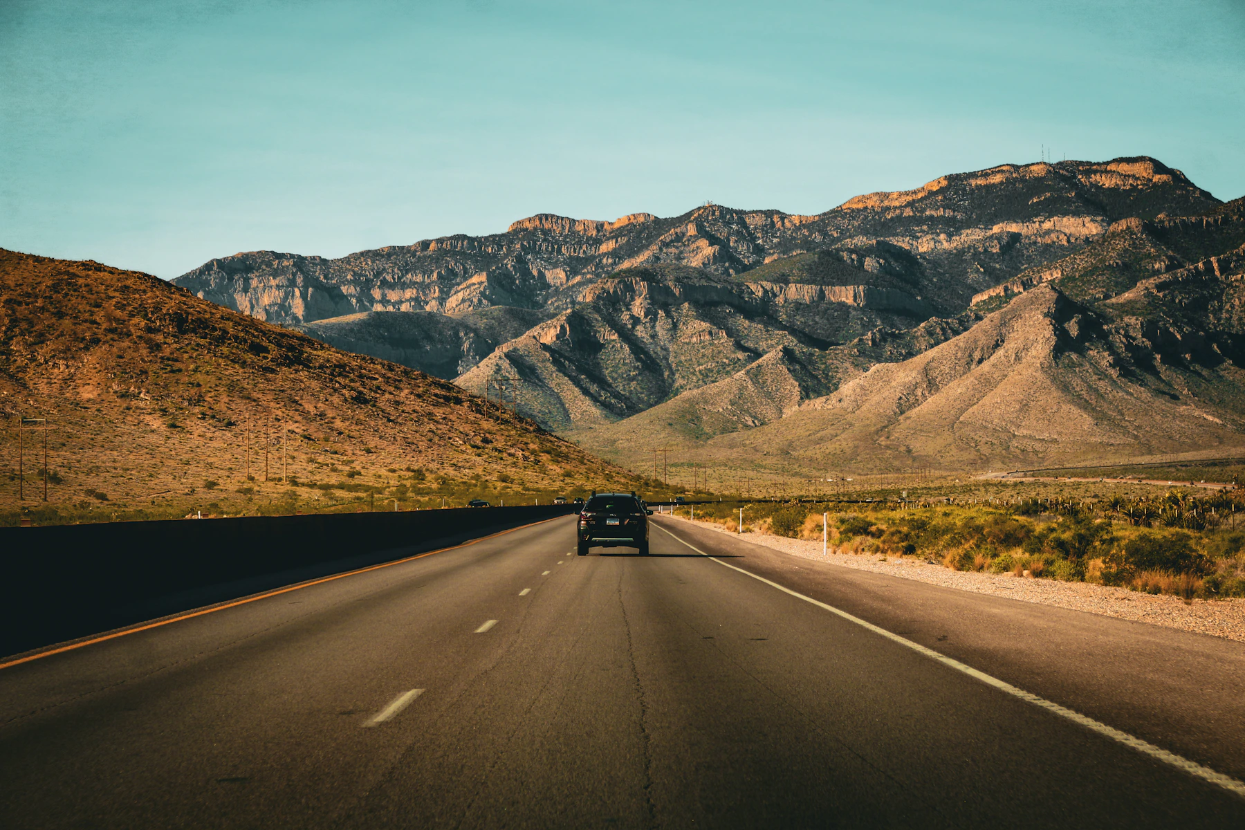 Car travelling on a highway toward mountains