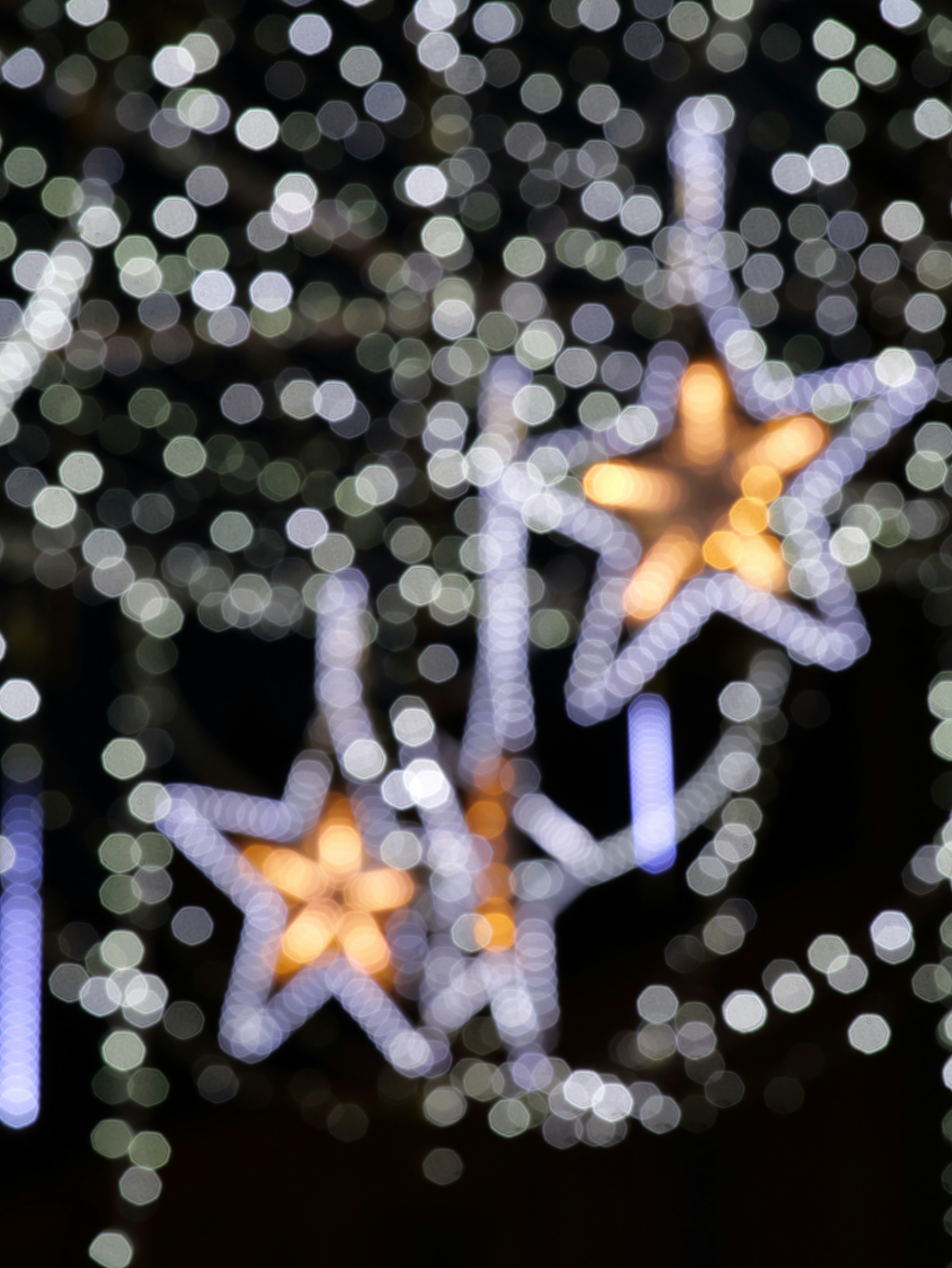 Out of focus star-shaped lights against a dark background