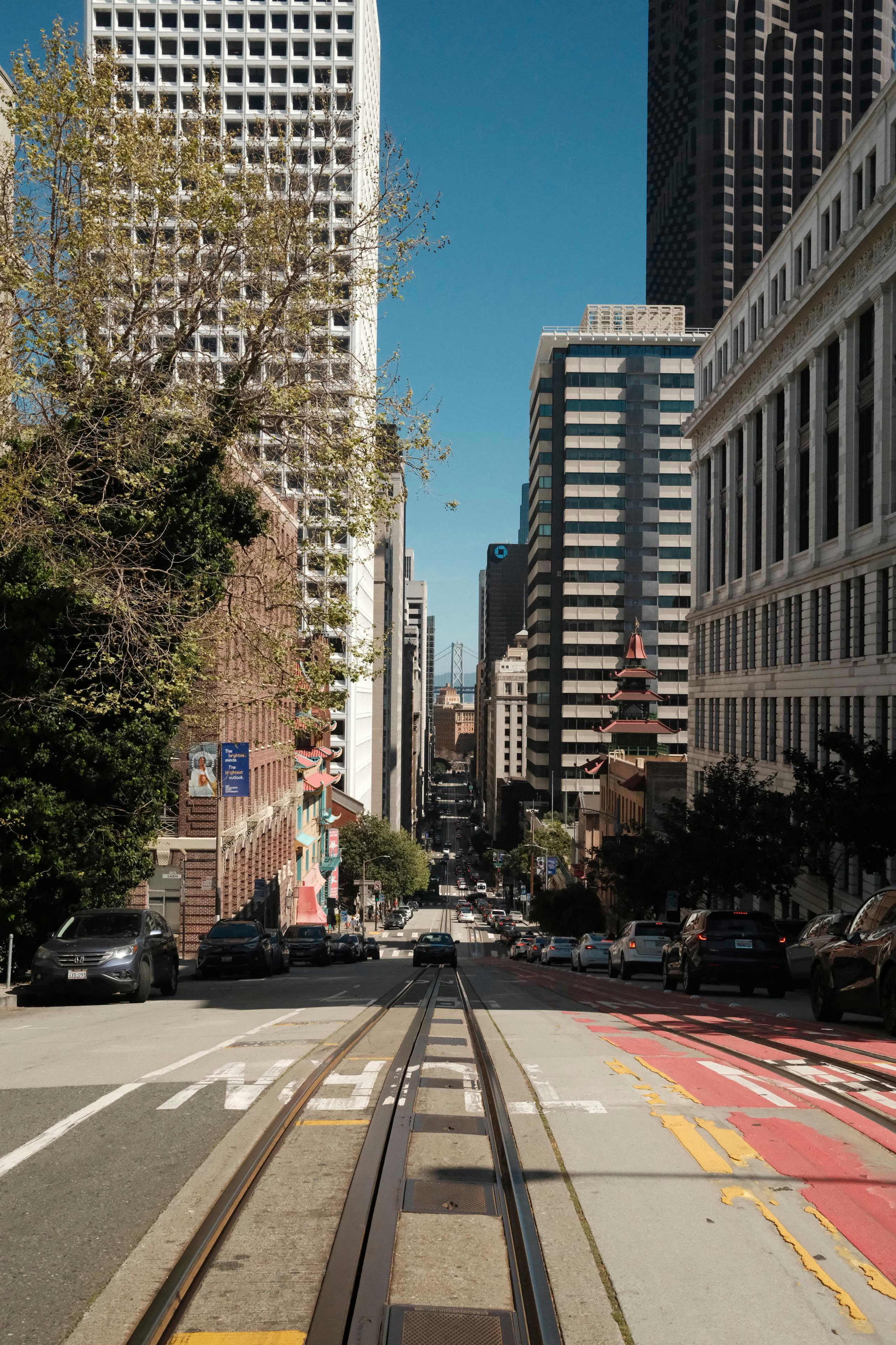 Calle de la ciudad con vías de teleférico y edificios altos