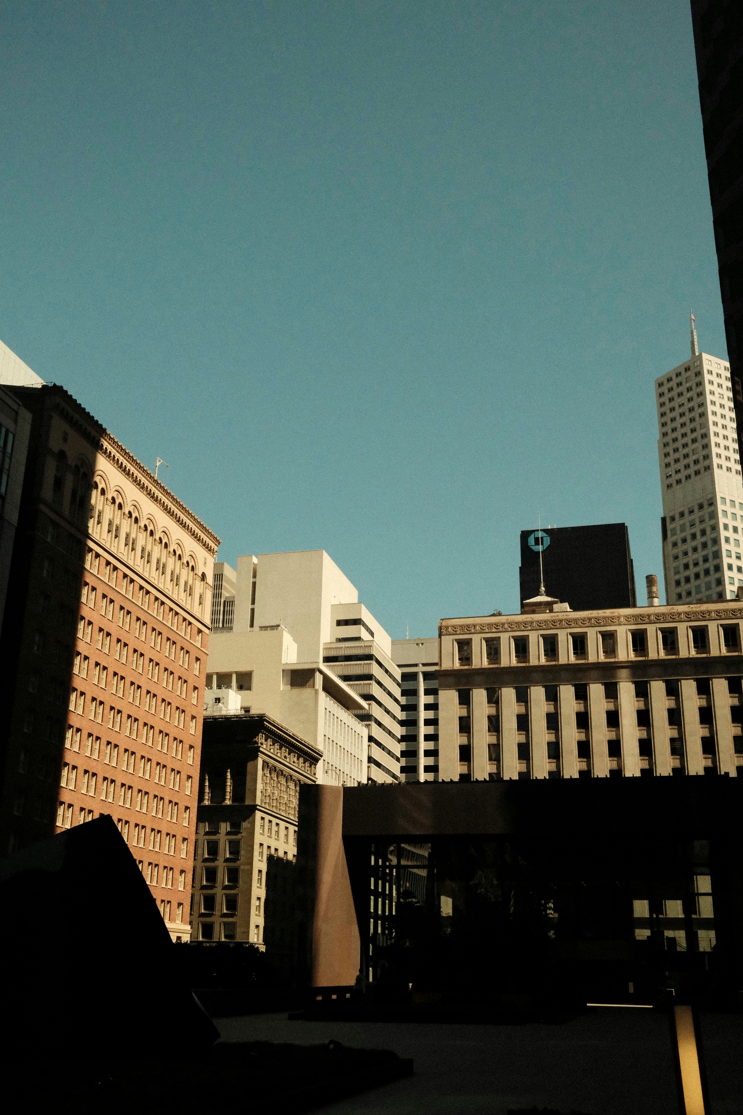 Modern city buildings under a clear blue sky.