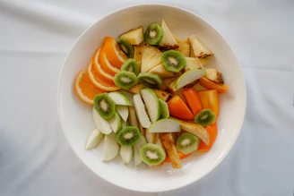A bowl of fresh fruit salad with oranges and kiwi