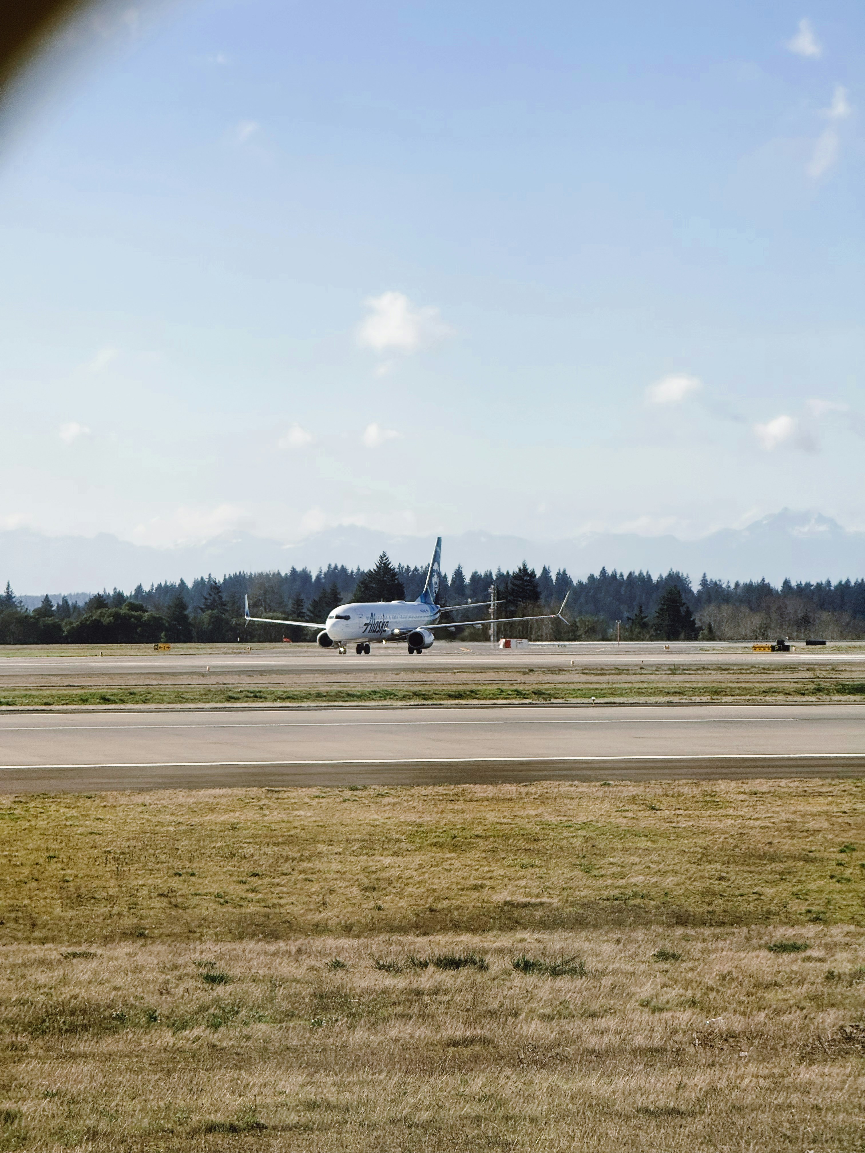 Un avion roulant sur une piste avec des montagnes en arrière-plan.
