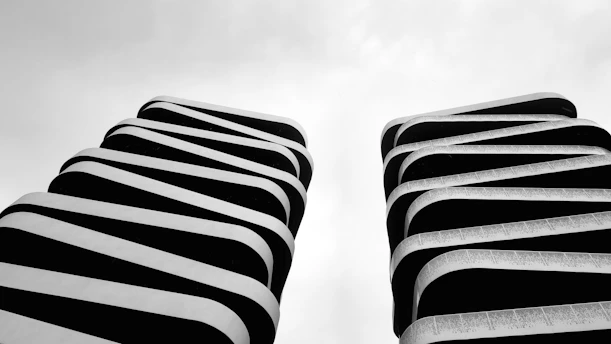Two abstract buildings with curved black and white stripes