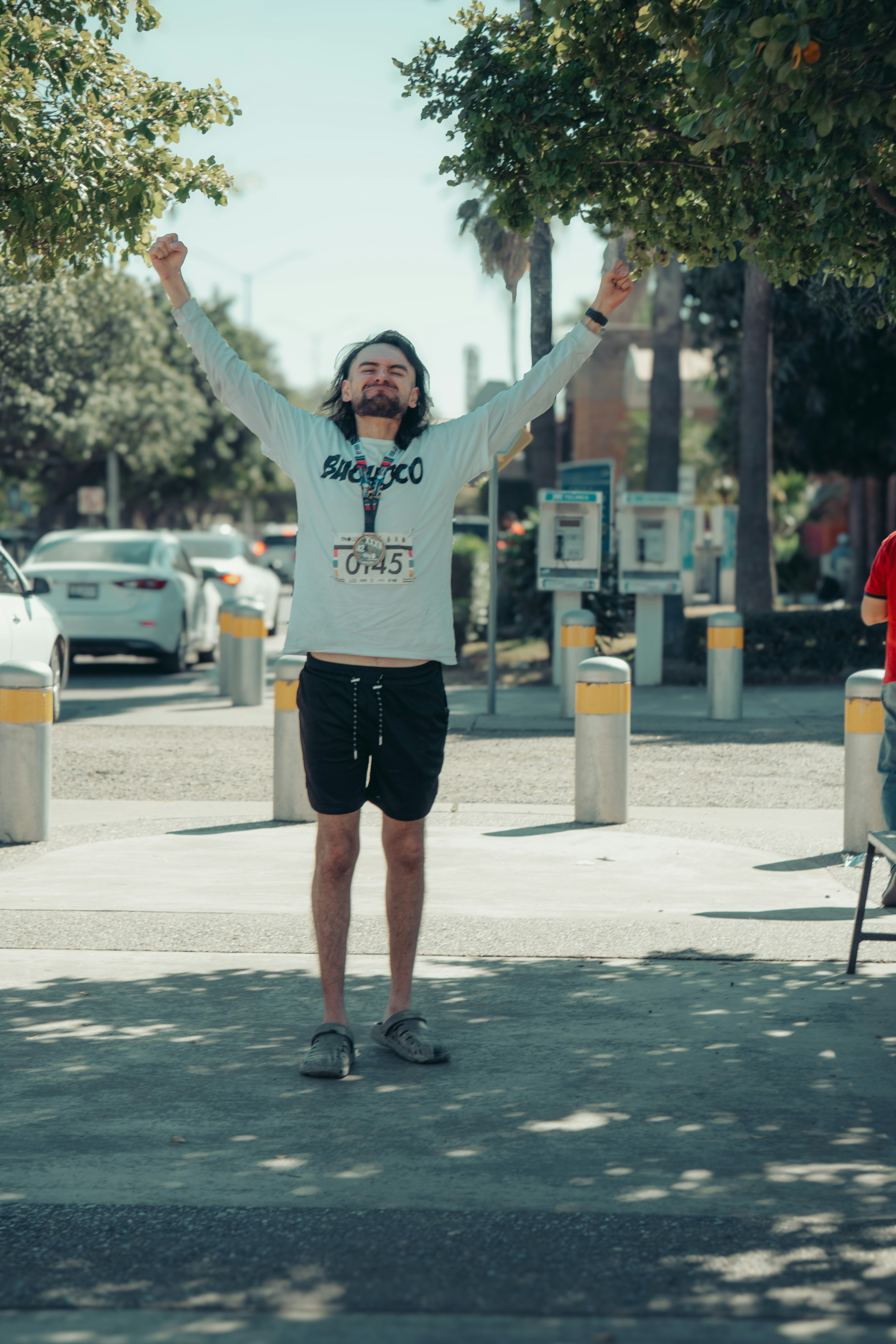 Man with arms raised in celebration outdoors