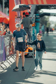 Man and child holding hands at finish line