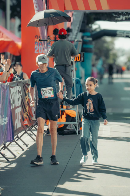 Man and child holding hands at finish line