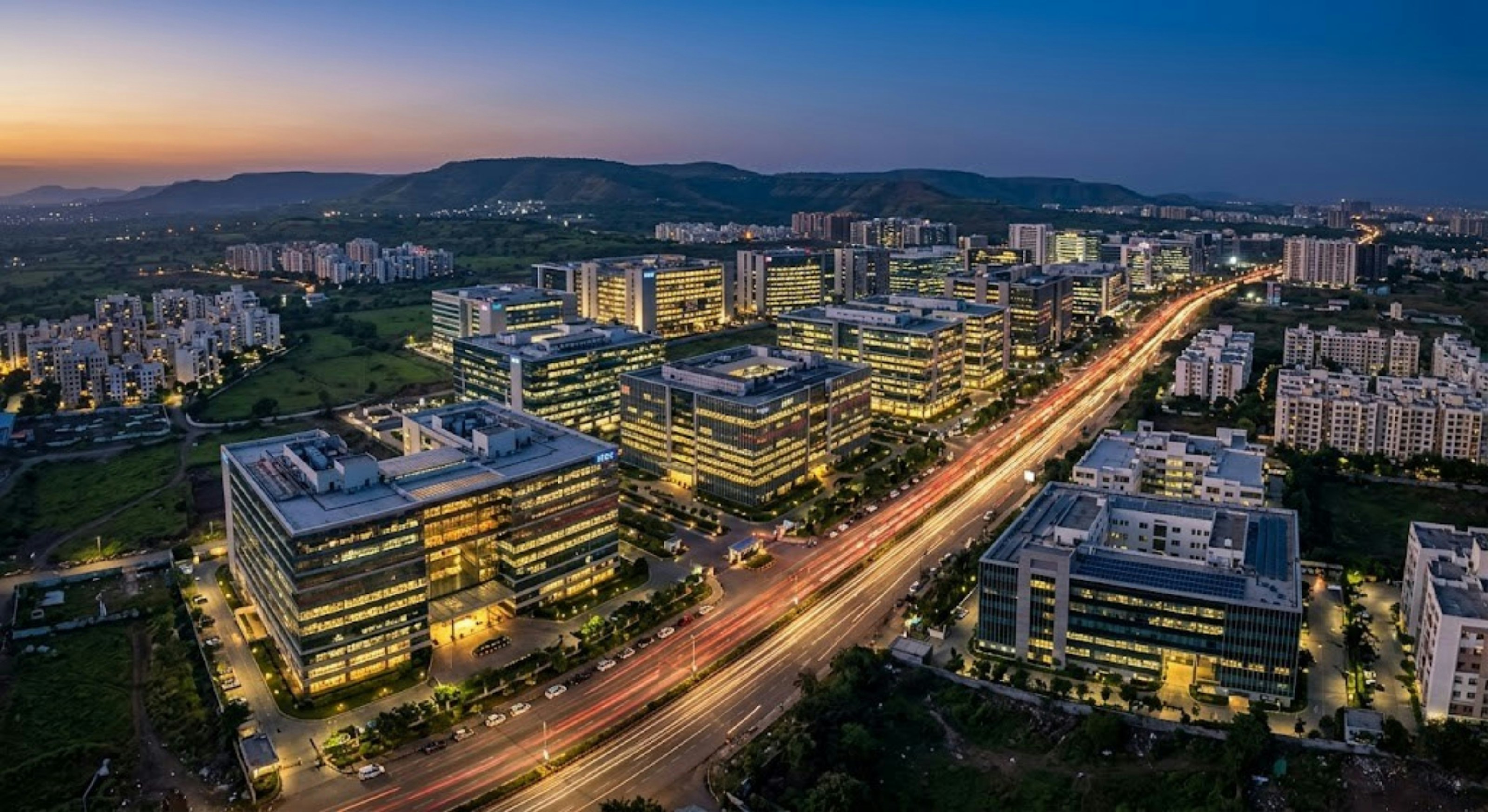 Modern cityscape with illuminated buildings and highway at dusk
