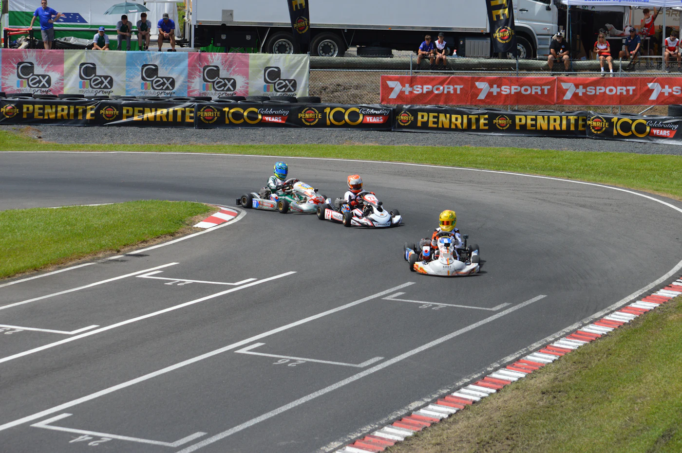Drie go-karts nemen een bocht op de baan