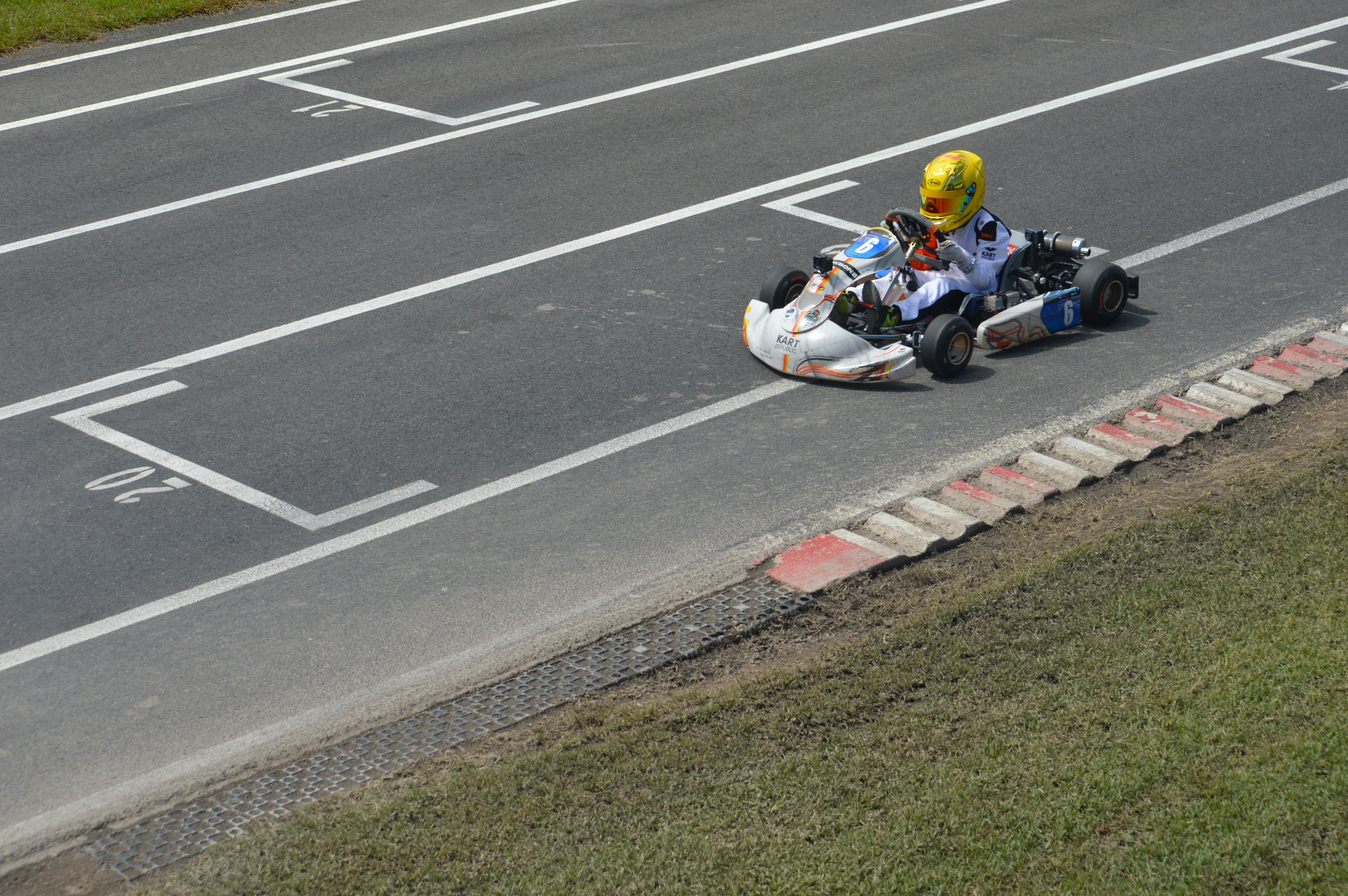 Un kart corre en una pista con líneas blancas.