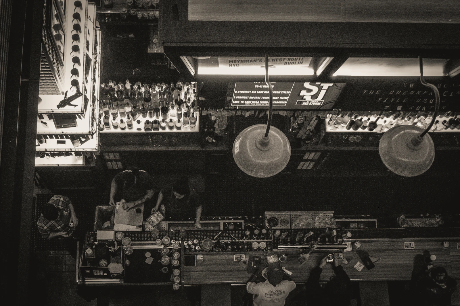 Intérieur de pub avec bouteilles et lampes suspendues, ambiance feutrée
