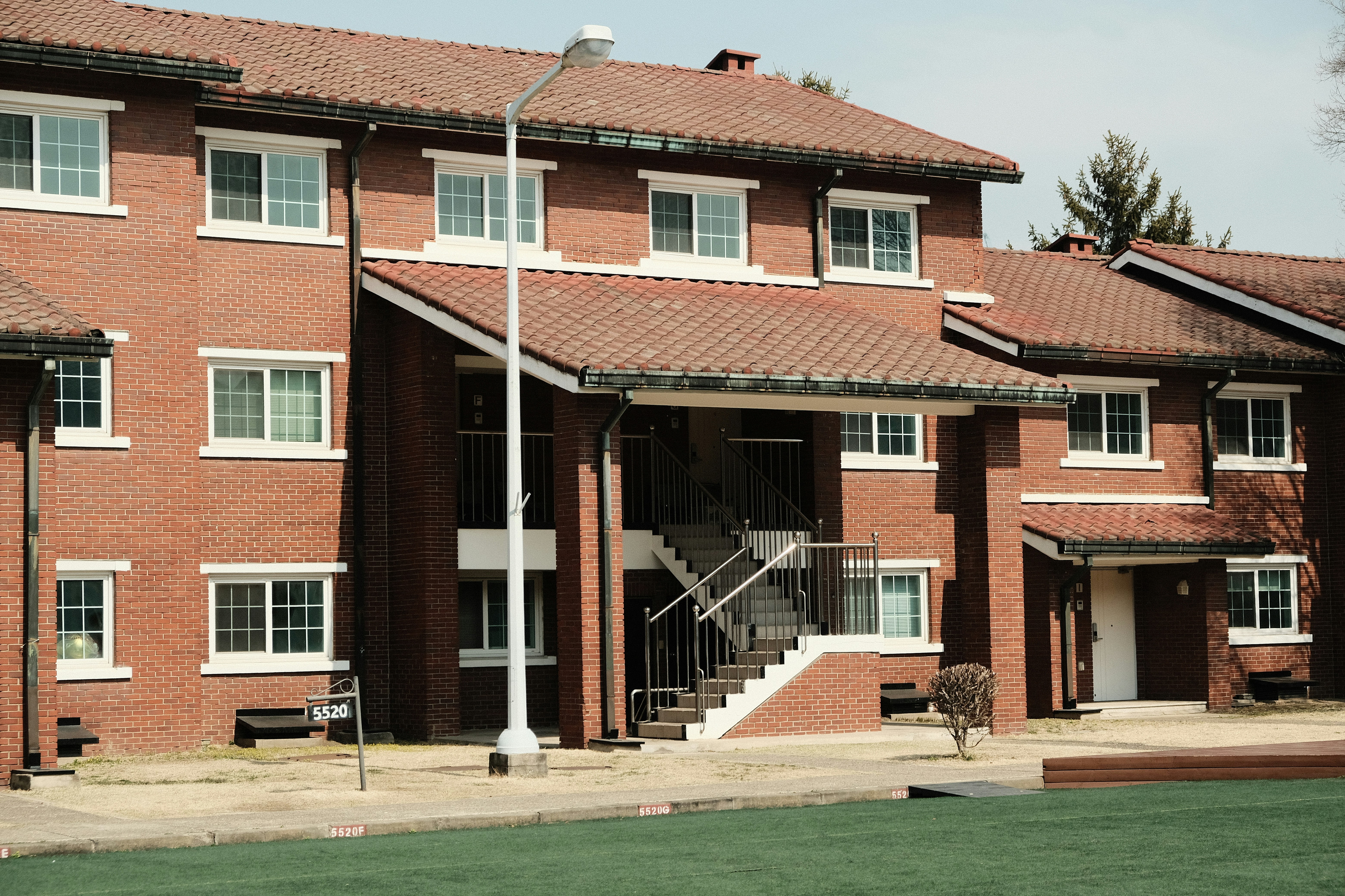 야외 계단과 창문이 있는 벽돌 아파트 건물