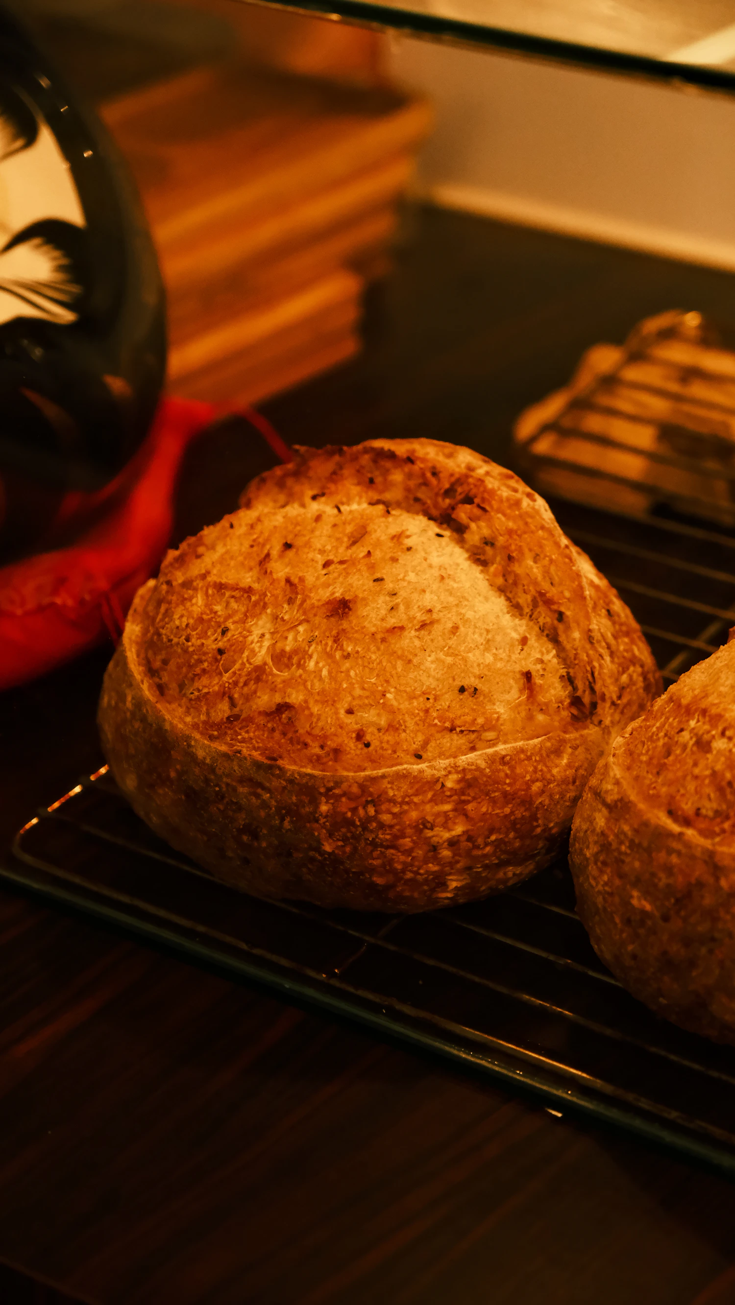 A dark crusted loaf close up in low warm light
