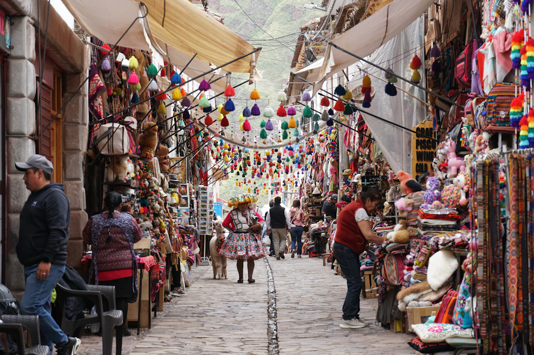 Colorful market stalls line a narrow cobblestone street