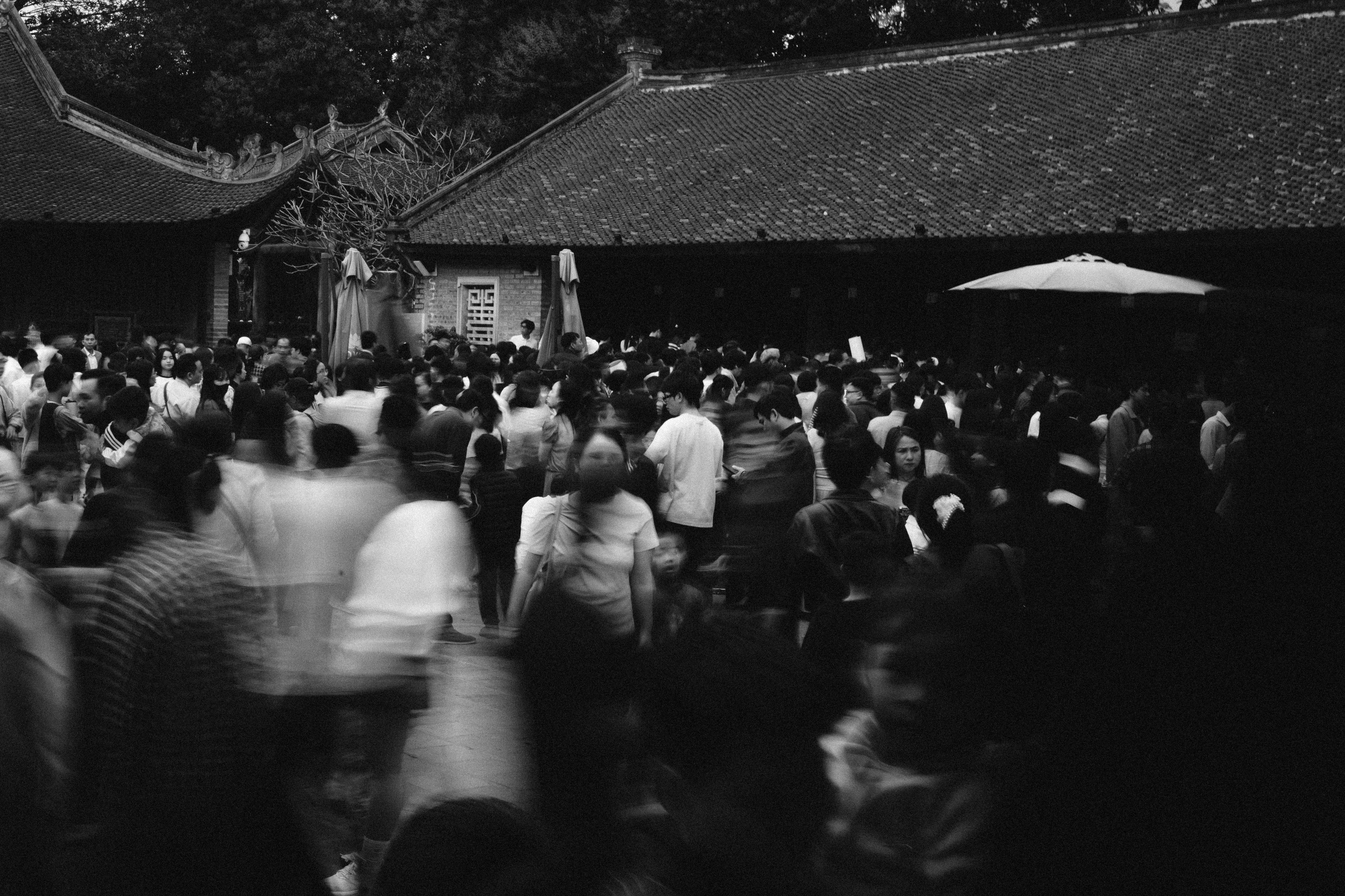 A crowd of people gathered in an outdoor courtyard.