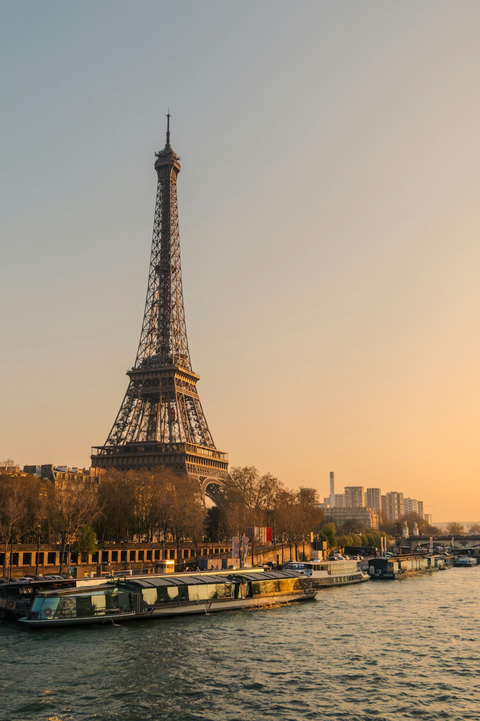 The Eiffel Tower and the Seine River at sunset with a cruise boat on the water