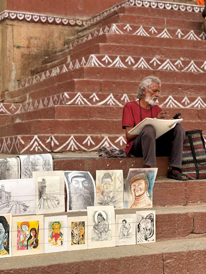 Artist sketching on steps with artwork displayed