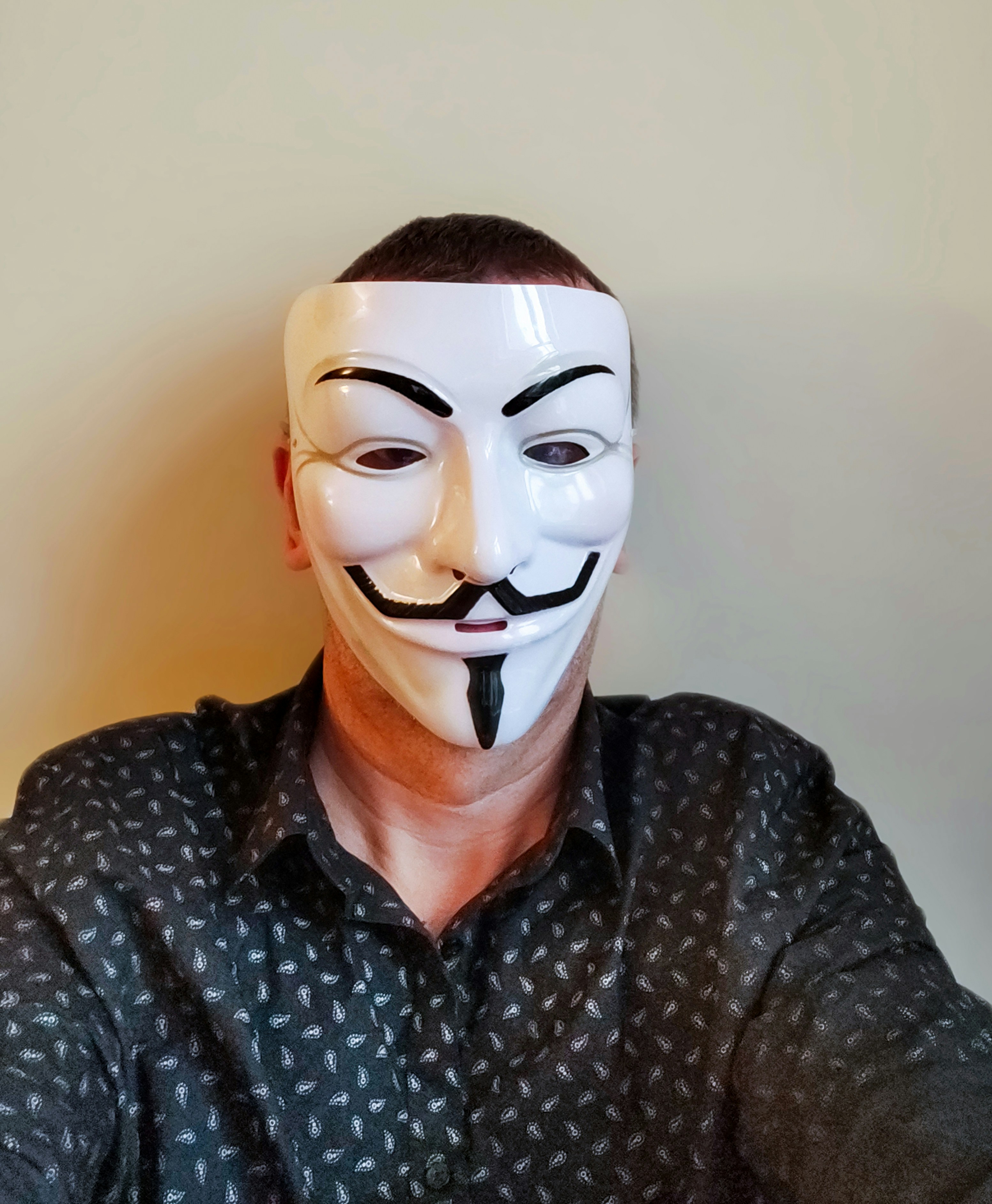 Pessoa usando máscara de um cara Fawkes e camisa estampada