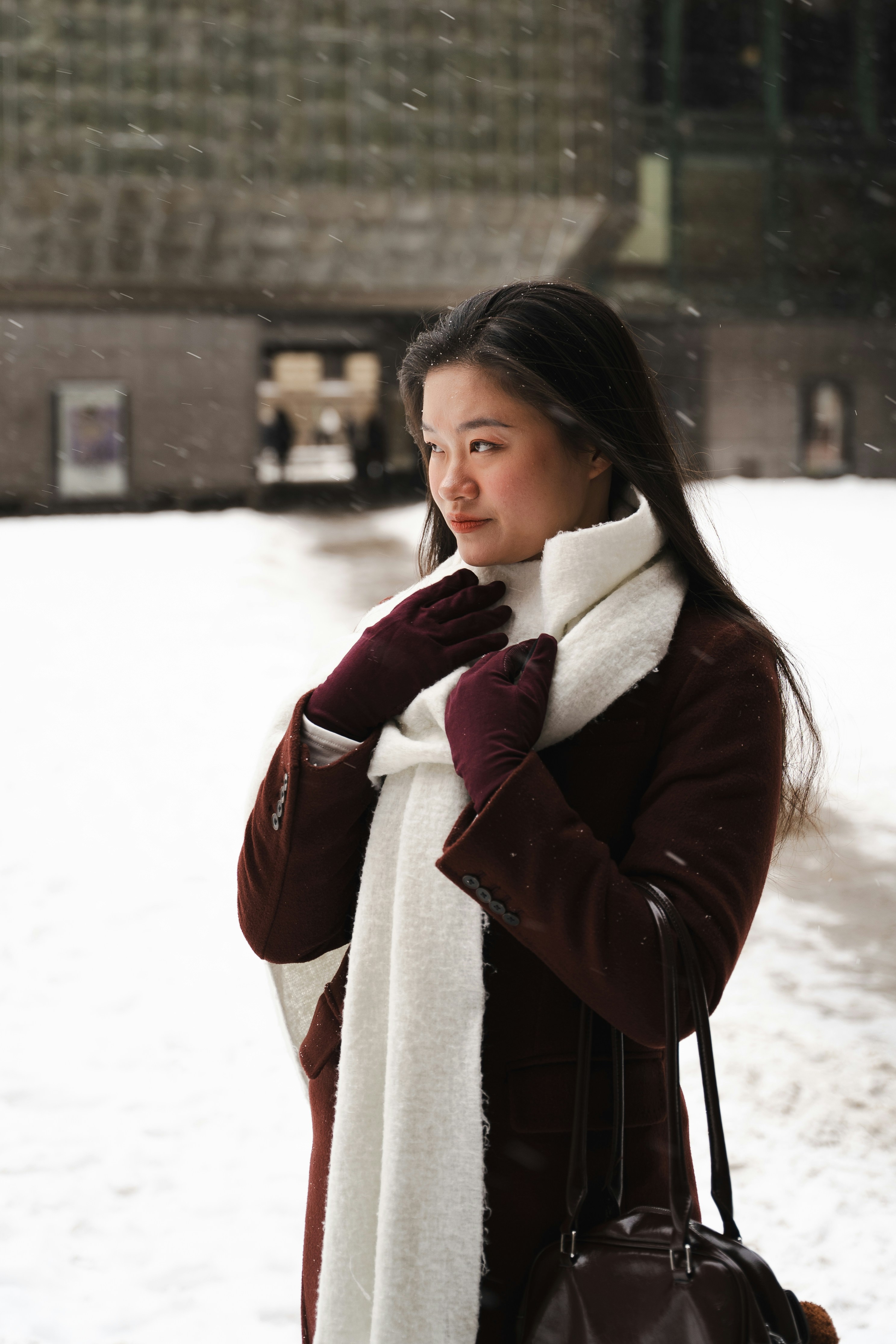 A woman in a coat and scarf in the snow