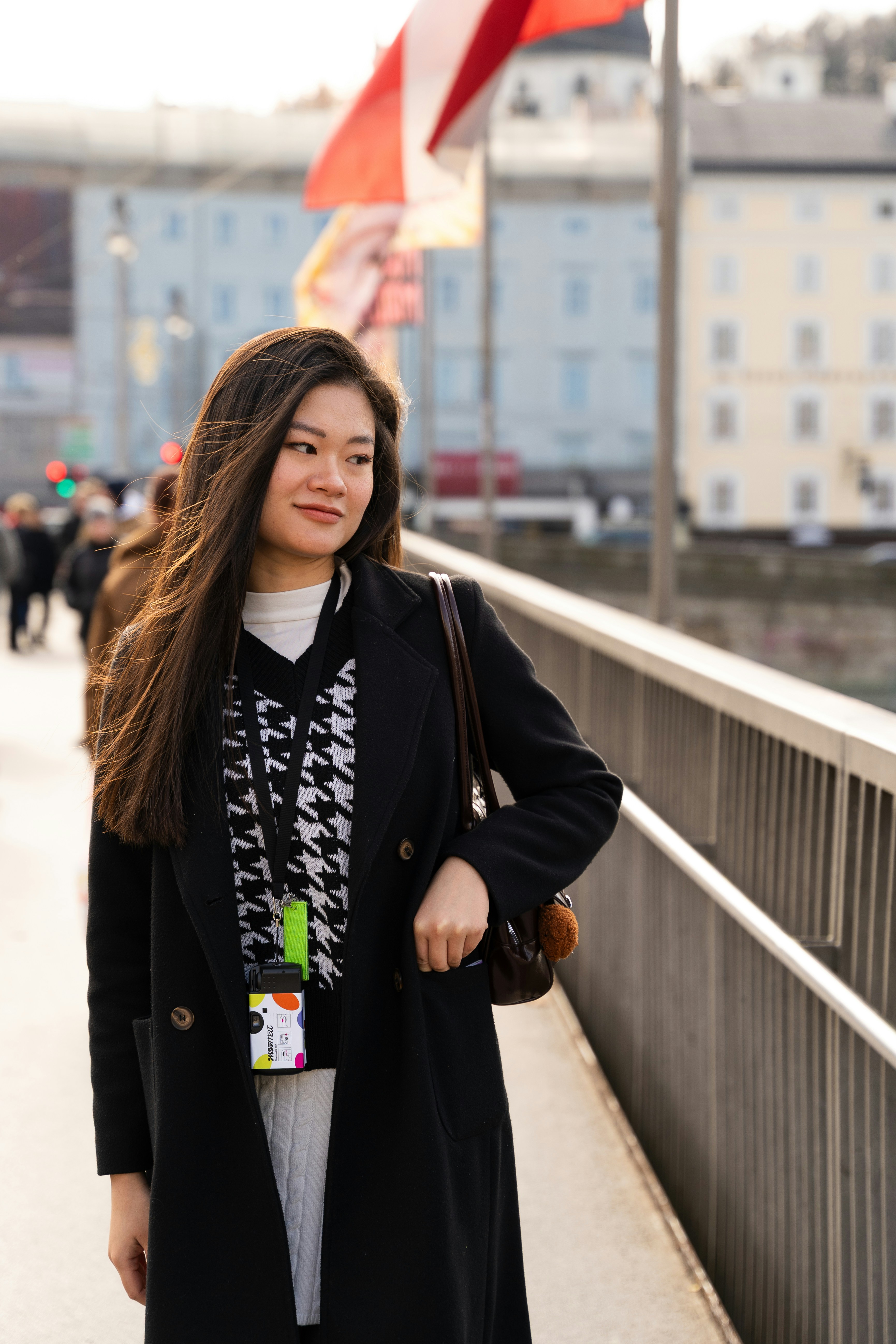 Young woman walking on a bridge with buildings behind