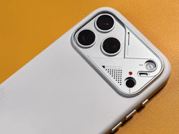Close-up of a white phone case with multiple camera lenses.